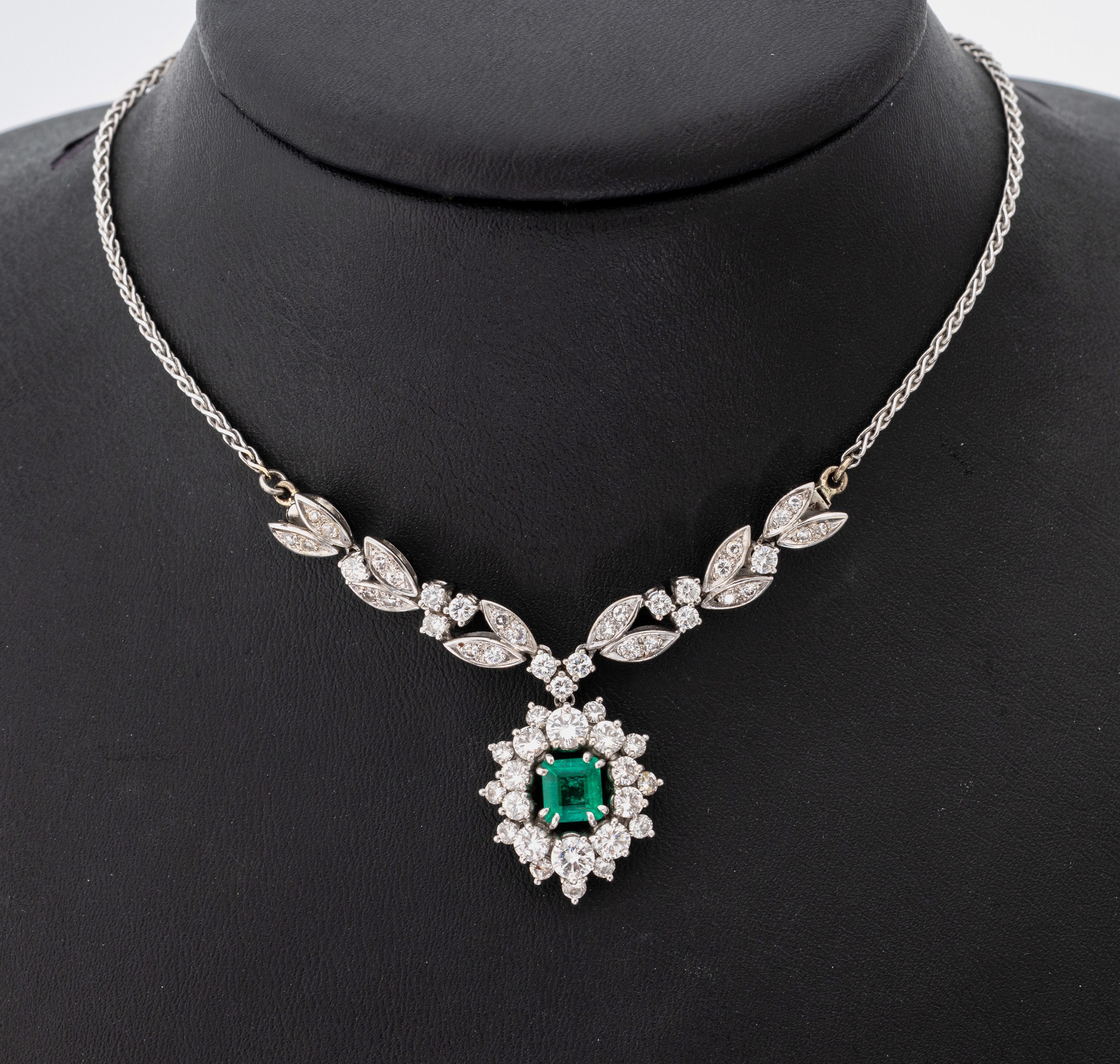 18 kt Gold Smaragd-Diamant-Collier, WG 750/000, Mittelteil mit bewegl. Abhängung, mittig Smaragd im Treppenschliff ca. 1.0 ct, 42 Brillanten und 13 ...