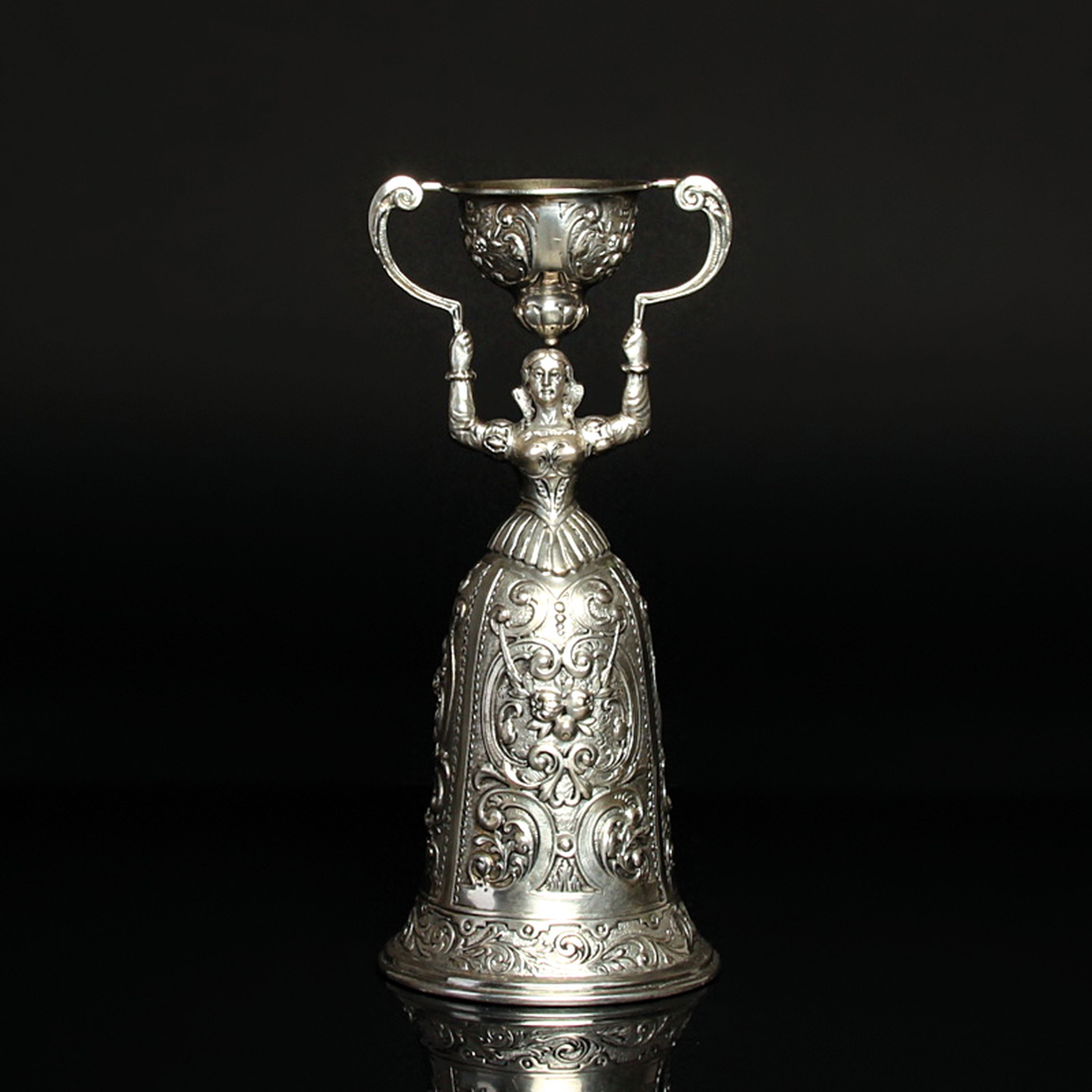 Hochzeitsbecher, wohl Hanau um 1900, 800er Silber, in Form einer Braut, die einen Becher über ihren Kopf hebt, aufwendig verziert mit Rocaillen und ...
