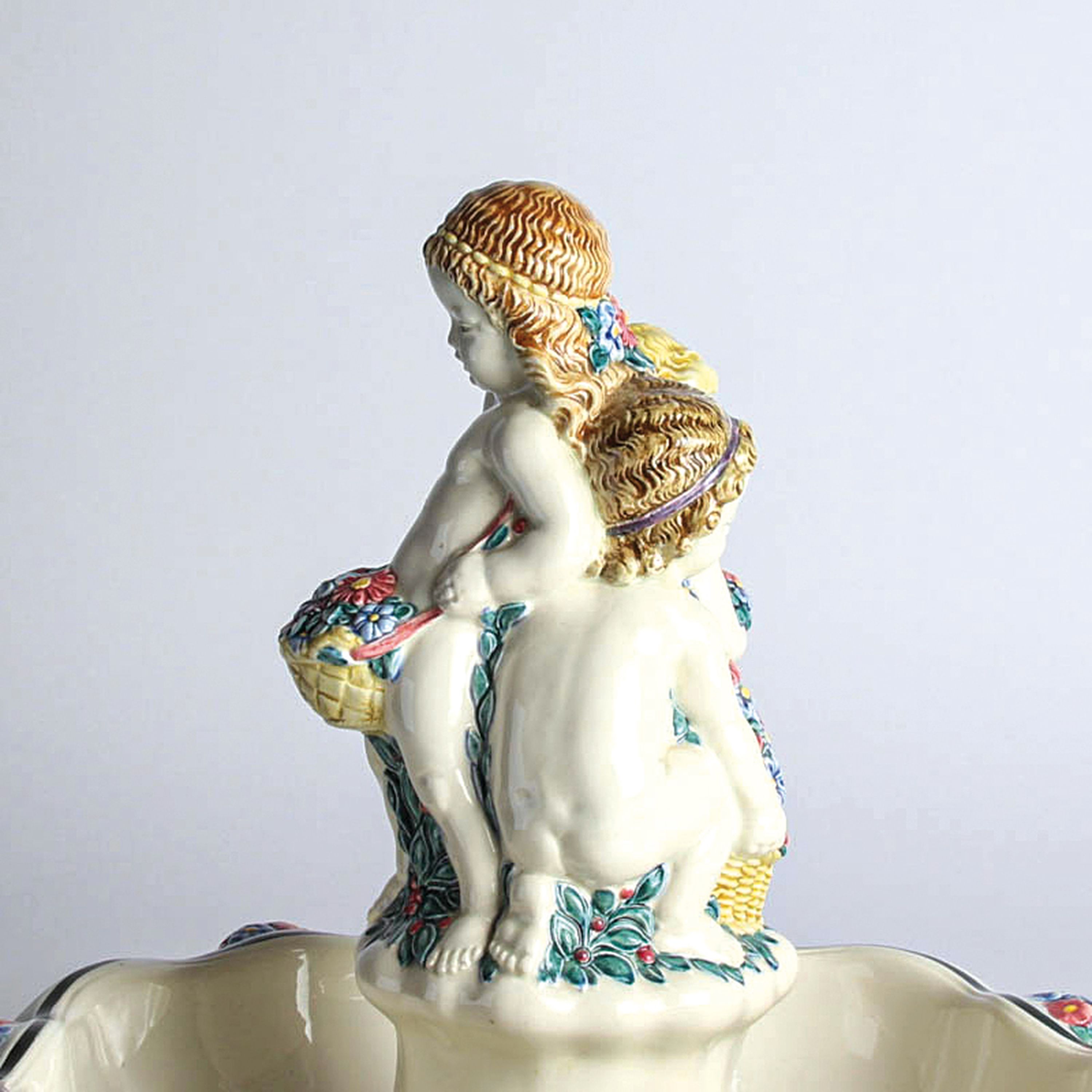 Detail d: Grosser Tafelaufsatz, Karlsruher Majolika, 'Fruchtschale mit 3 Mädchen', 1913 Entwurf Heinze, Modellnr. 1313, polychrome Unterglasur ...