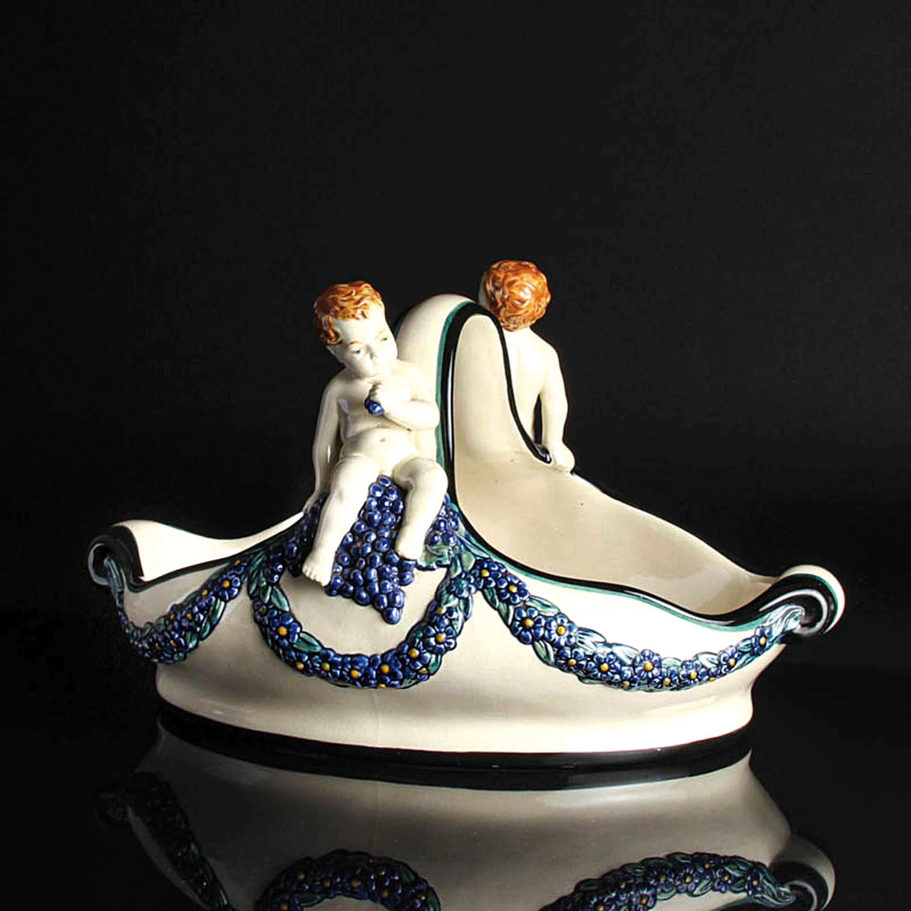 Detail c: Henkelschale mit Traubenputti, Karlsruher Majolika, Entw. Wilhelm Süß (1861-1933), Modellnr. 1164, Keramik, farbig staffiert, Blumenghirlanden und ...