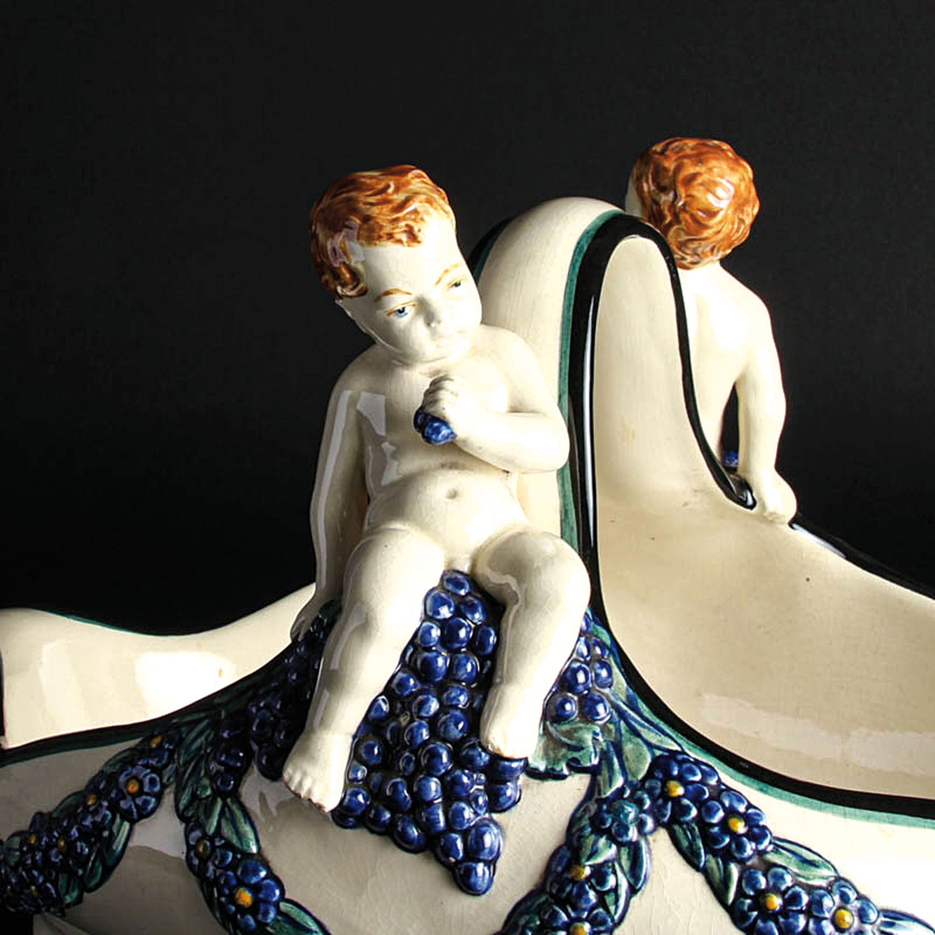 Detail d: Henkelschale mit Traubenputti, Karlsruher Majolika, Entw. Wilhelm Süß (1861-1933), Modellnr. 1164, Keramik, farbig staffiert, Blumenghirlanden und ...