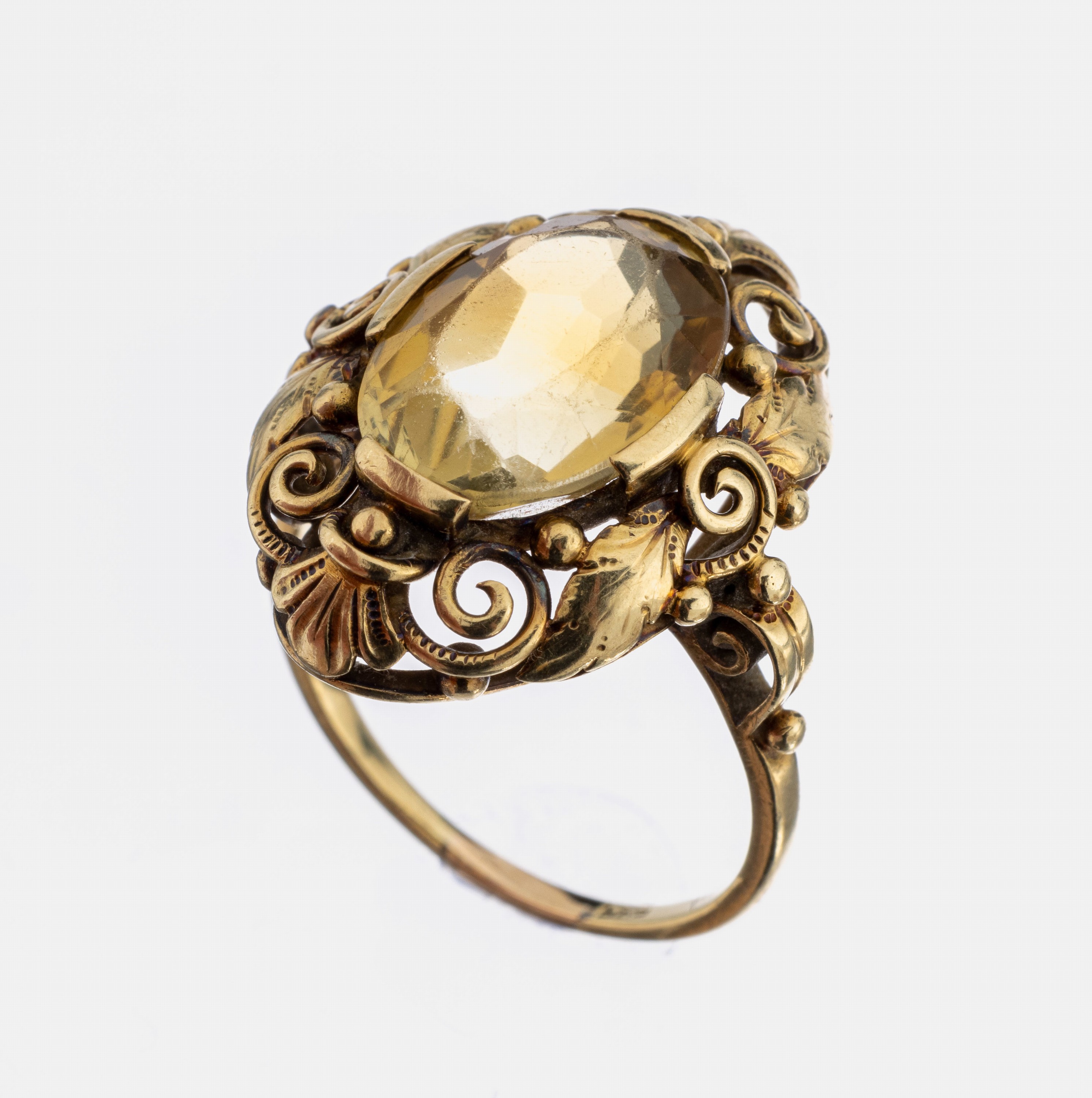 14 kt Gold Ring, 1950er Jahre, GG 585/000, Rahmung aus Blättern und Voluten, mittig ovalfacett. citrinfarb. Glasstein, Facetten stark abgetragen, ...