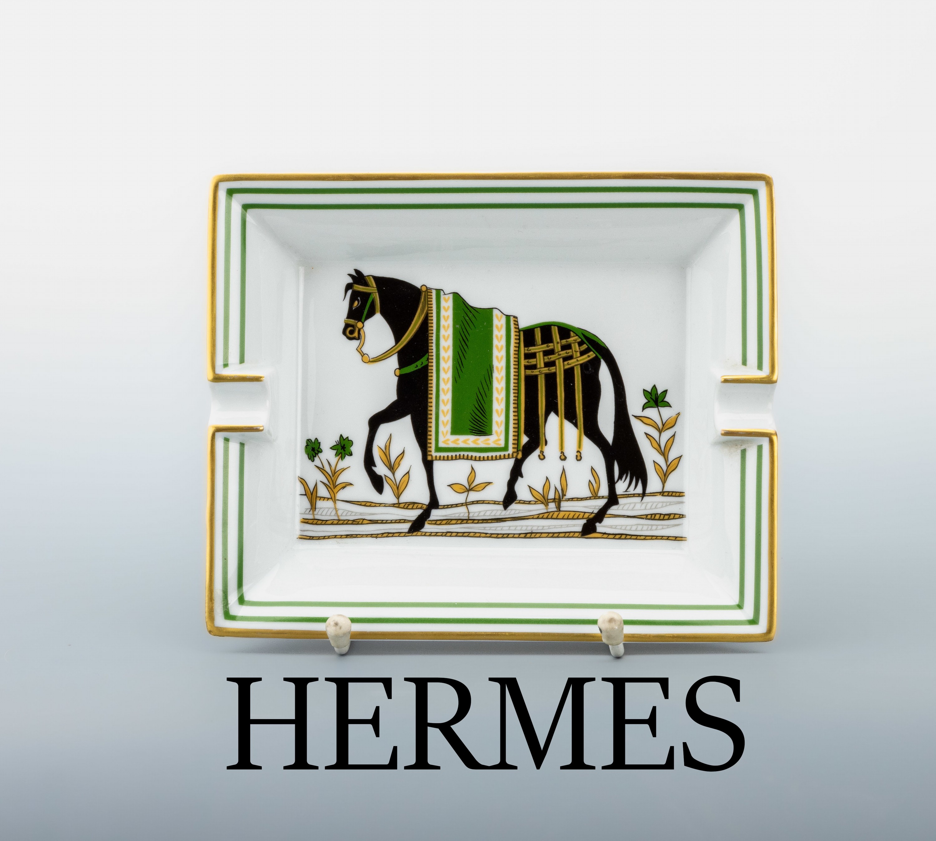 HERMES Aschenbecher, Porzellan mit polychromen Dekor, Darstellung eines Rappen mit grüner Decke, Boden mit Wildleder, ca. 19.5 x 16 cm, Made in ...