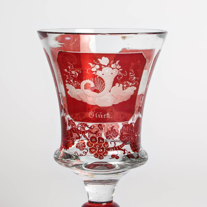 Detail c: Andenkenglas, Böhmen, Mitte 19. Jh., farbloses Glas rubiniert, 3 fein geschliffene Kartuschen: Gesundheit, Glück und Freude, Weinlaub, H. ca. ...