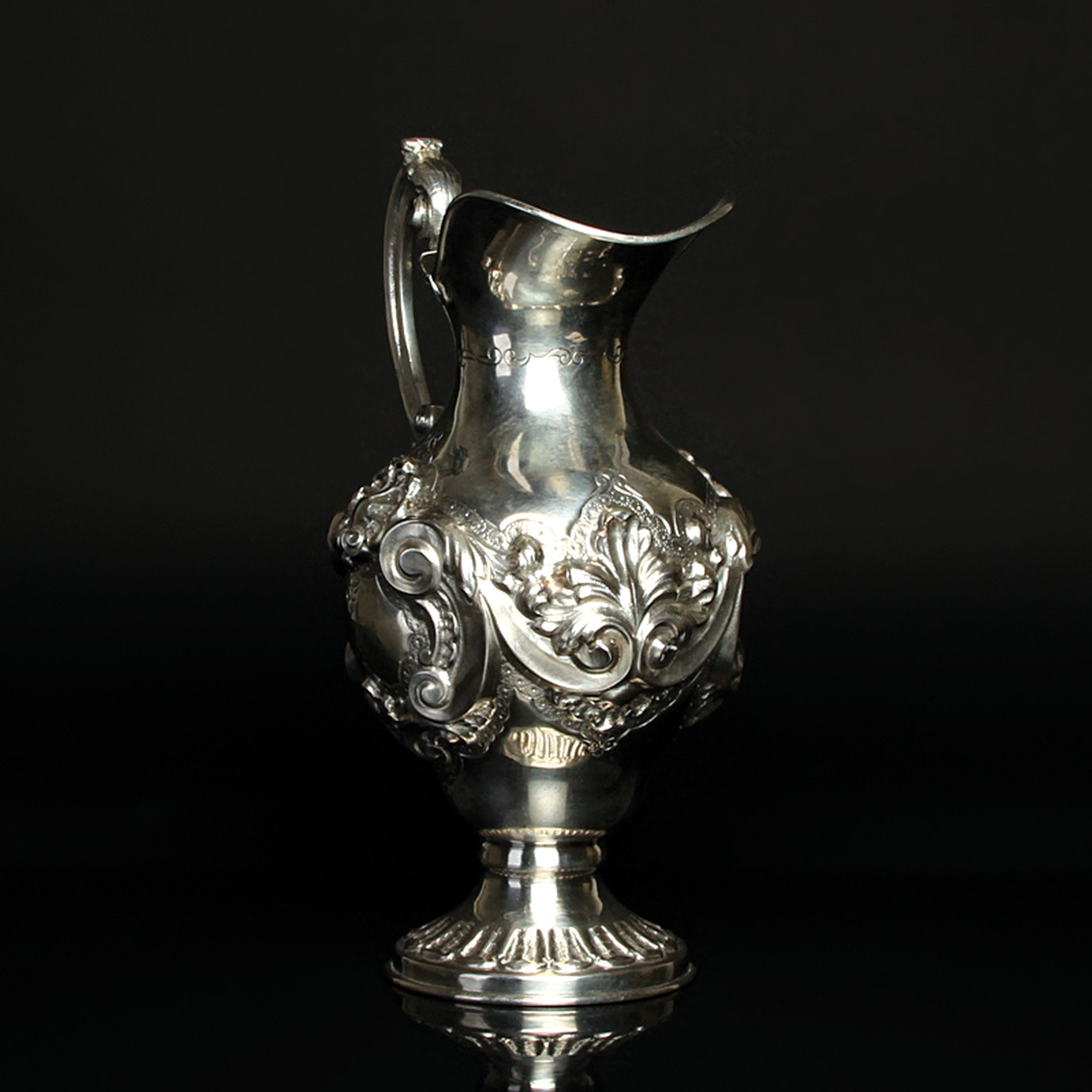Detail e: Kanne, wohl Polen, um 1880-90, Silber, reich reliefiert mit Muschel- und Rocaillen- Dekor, punziert, H. ca. 23cm, ca. 550 g.