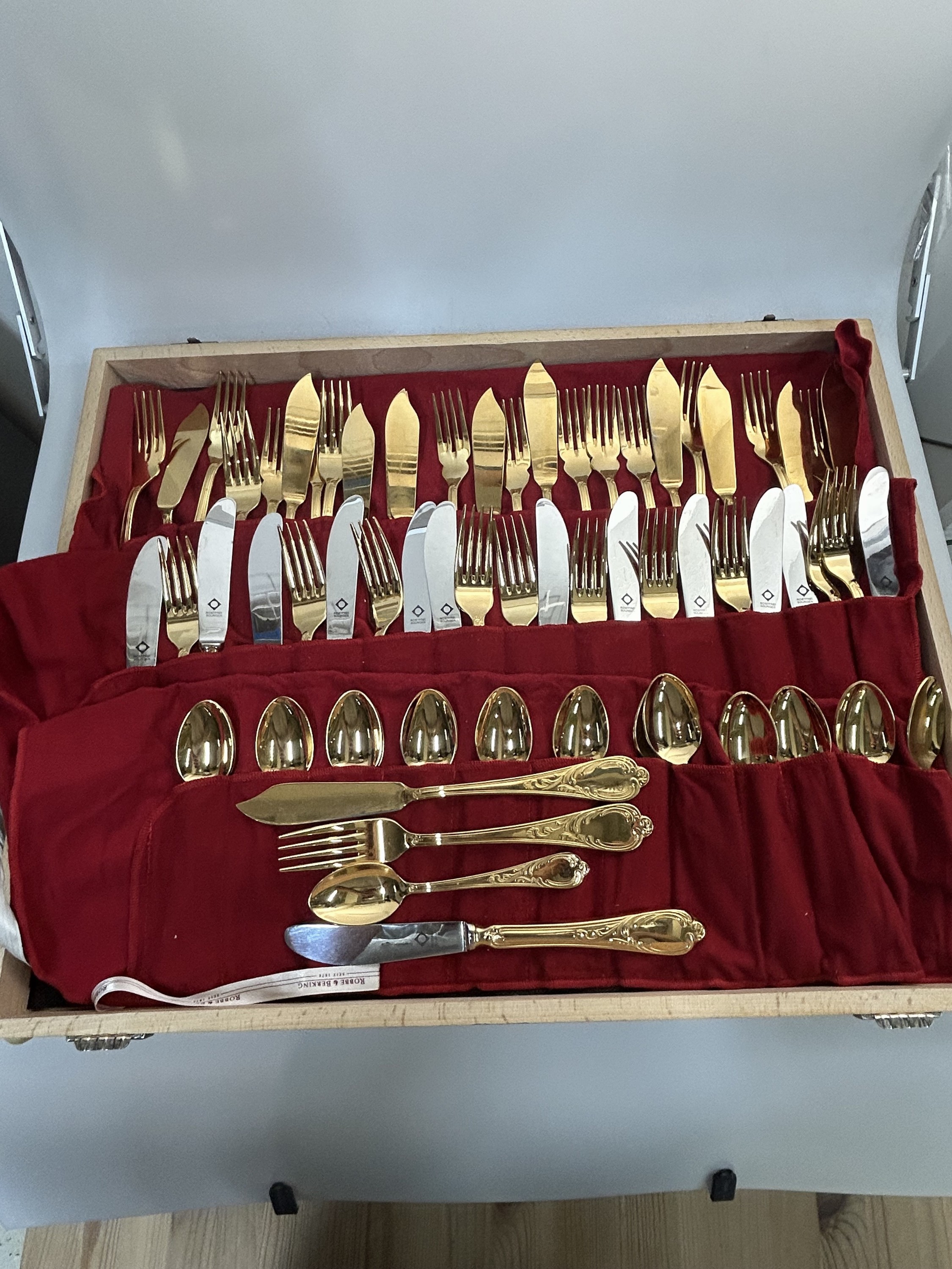 Detail b: 142-tlg. Tafelbesteck, Solingen, Edelstahl 23 Karat vergoldet, Barockstil, 24 Messer, 23 Gabeln, 24 Löffel, 12 Fischmesser, 12 Fischgabeln, 24 ...