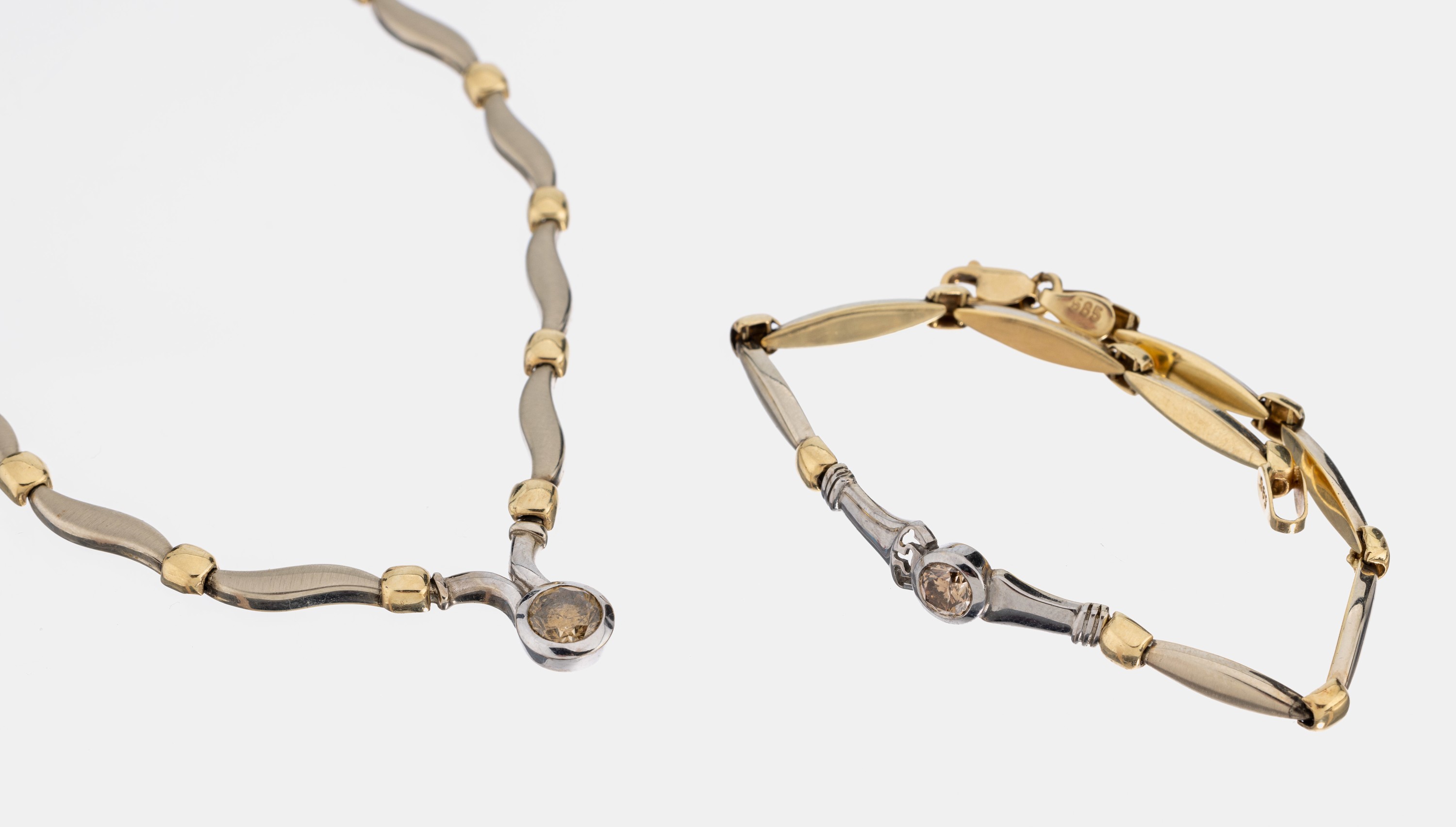 14 kt Gold Brillant-Schmuckset, WG/GG 585/000, part. sat., best. aus: Collier, L. ca. 41 cm, und 1 Armband, L. ca. 19.5 cm, jeweils mit 1 Brillant ...