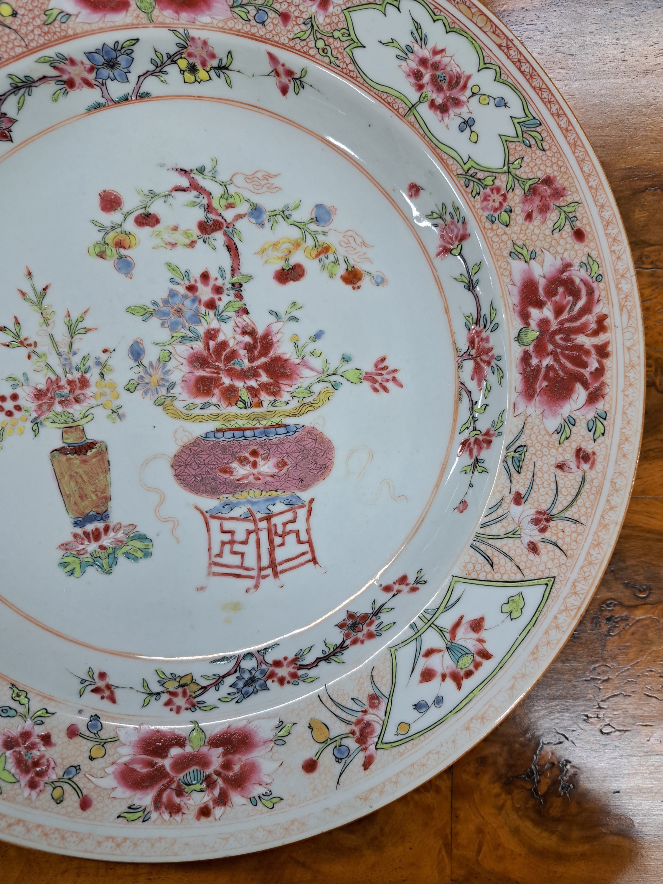 Detail d: Großer Teller, China, 19. Jh., Porzellan, mit Vasenmotiven und Blumen, Famile rose, leicht berieben, D. 31 cm, brauner Rand