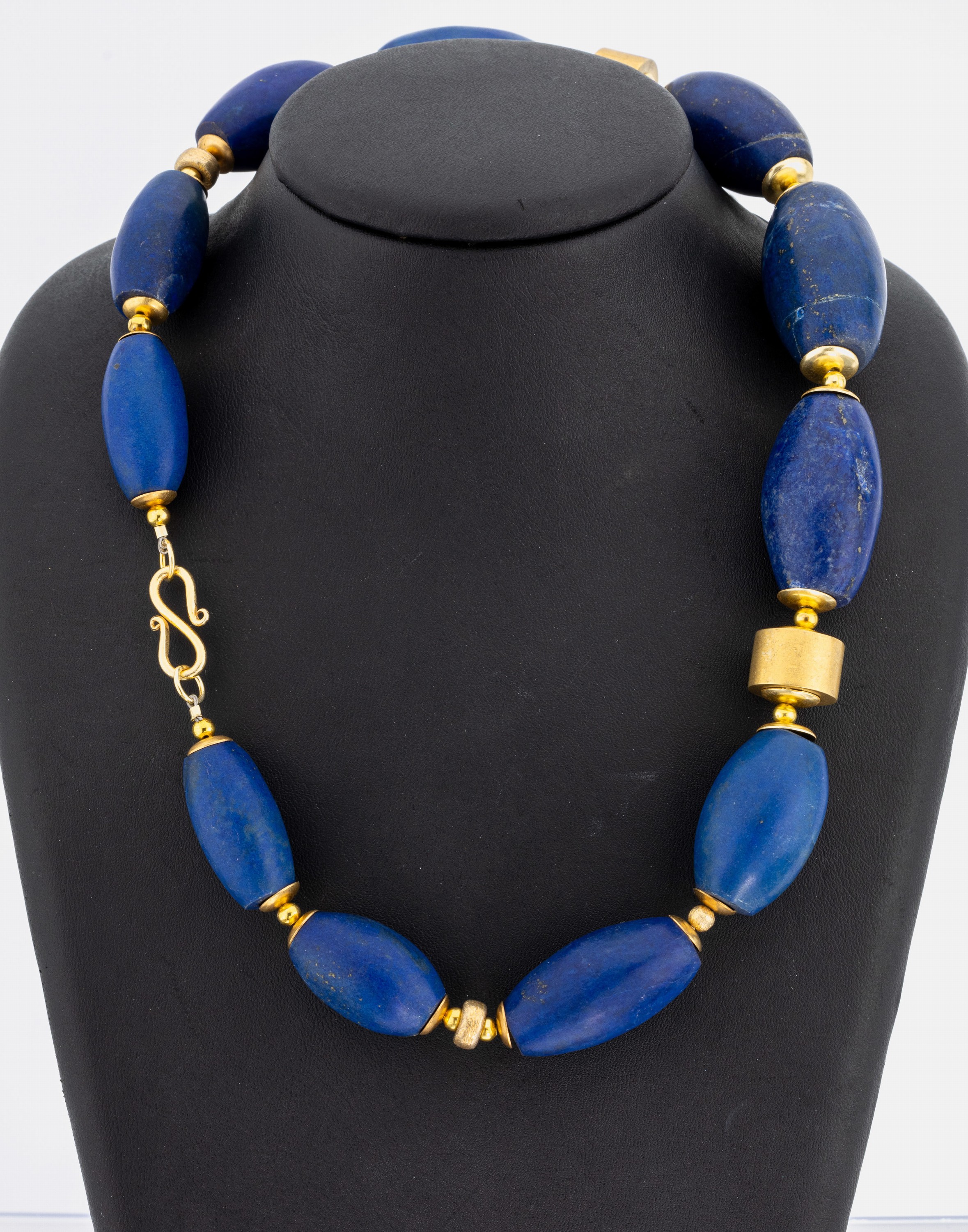 Ausgefallenes Lapislazulicollier, Indien 1960/70er Jahre, S-Schließe und Zwischenmonturen Silber vergoldet, ovale Lapis-Tönnchen, L. ca. 3 cm, ca. ...