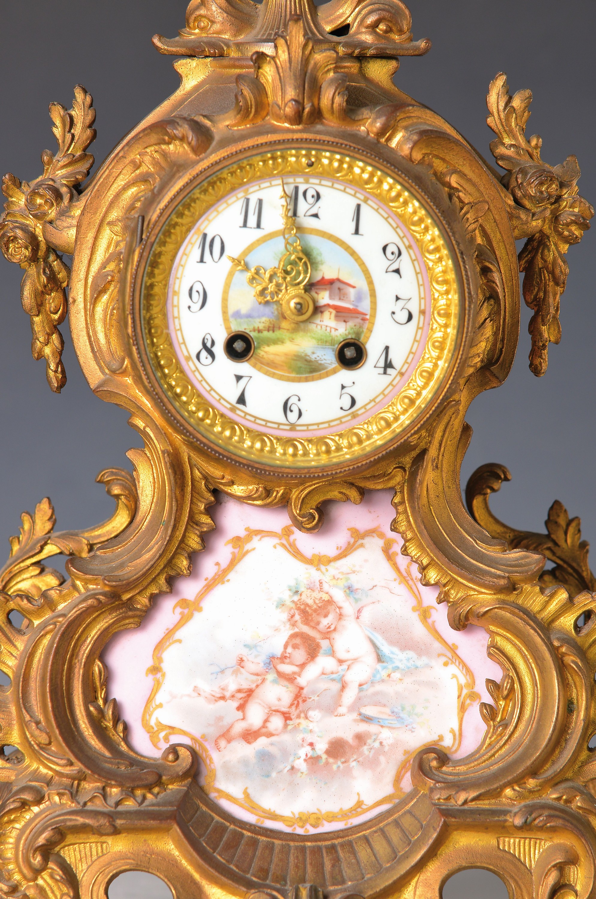 Detail d: Pendule, Frankreich, um 1890, verziertes Messinggehäuse in Rokokoform, mit Resten alterVergoldung, eine kleine Applikation fehlt, bemalte ...