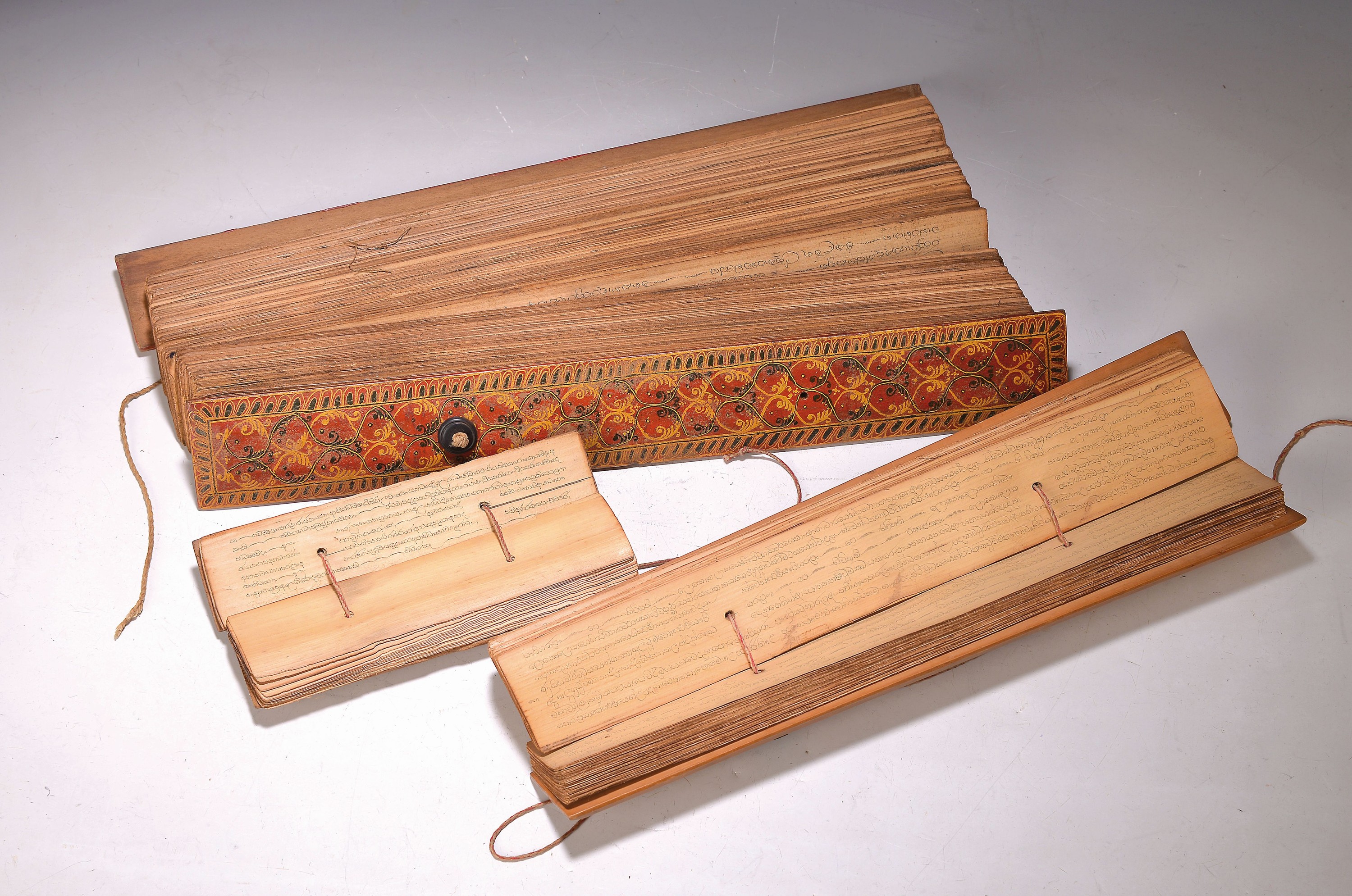 4 Palmblattbücher, Südostasien, um 1900, 1 mit verzierten Holzdeckeln, drei mit einfachen Holzdeckeln, L. ca. 48/43/23/15cm
