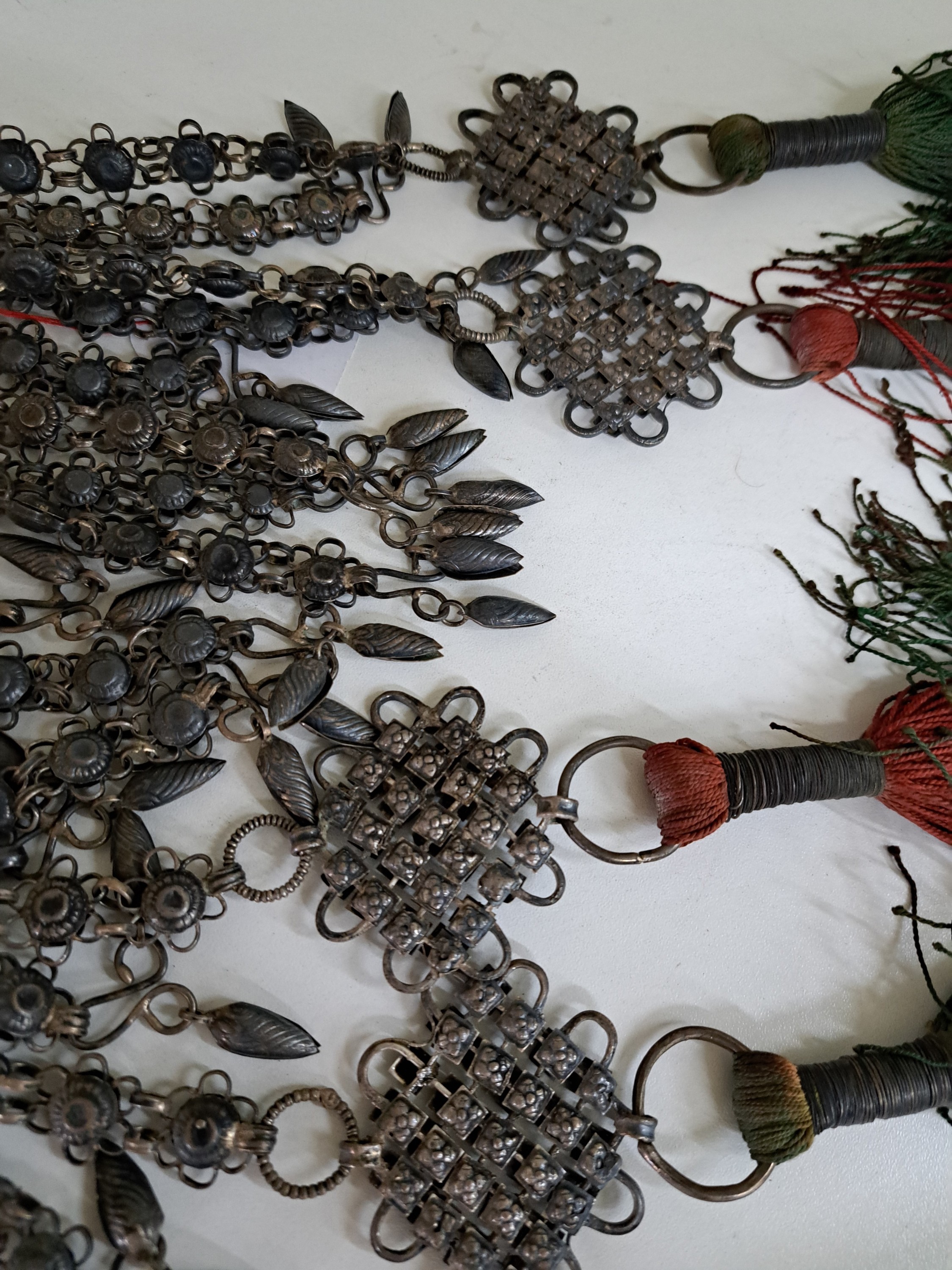 Detail d: 2 Schmuckappliken, Nordindien/Himalaya, um 1900, silberhaltiges Metall teils in Filigranarbeit, mit zahlreichen Abhängungen, Reste alten ...