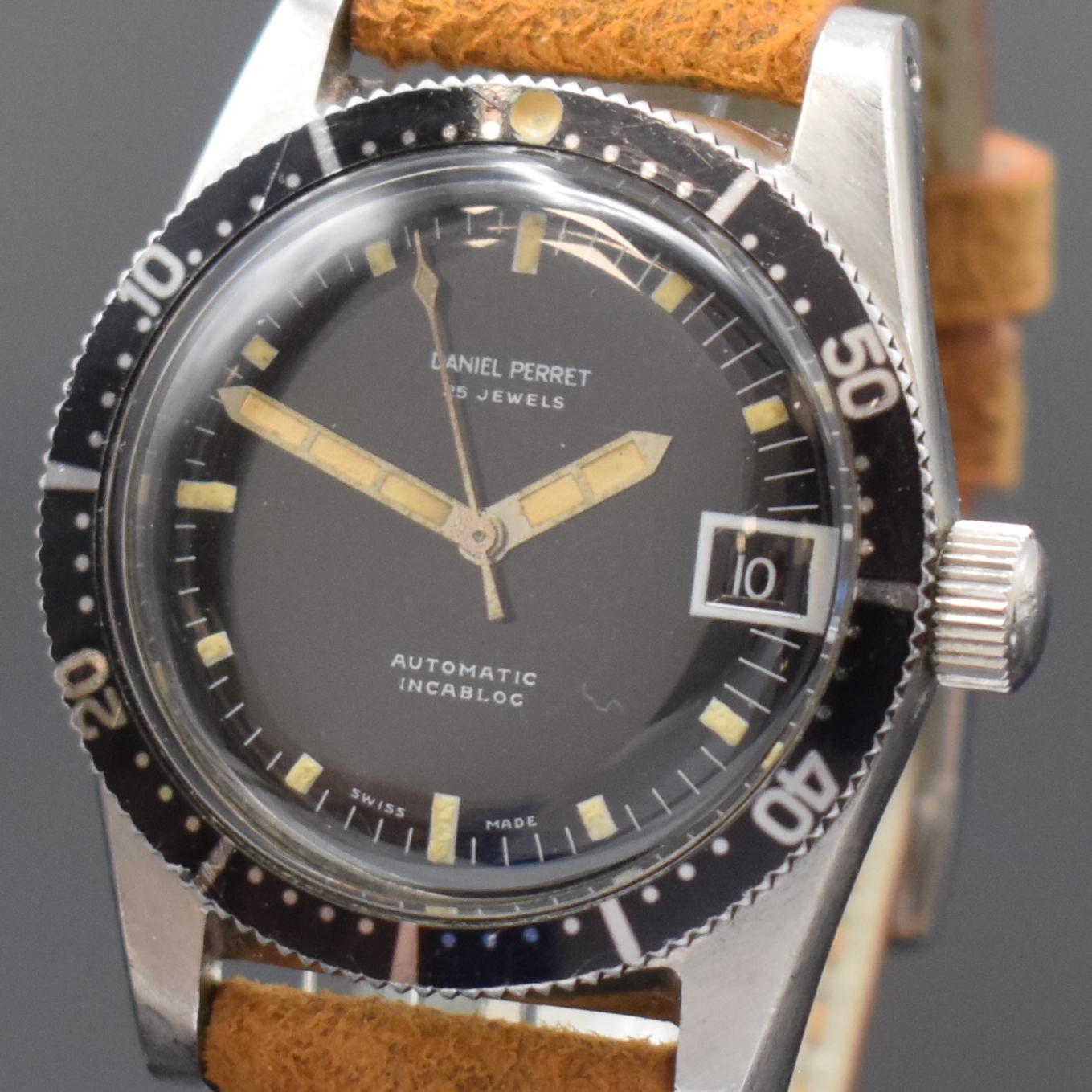 Detail a: DANIEL PERRET Herrenarmbanduhr, Schweiz um 1960, Automatik, Edelstahlgeh., Boden und Krone verschr., beids. drehb. Lünette m. 60er Teilung, ...