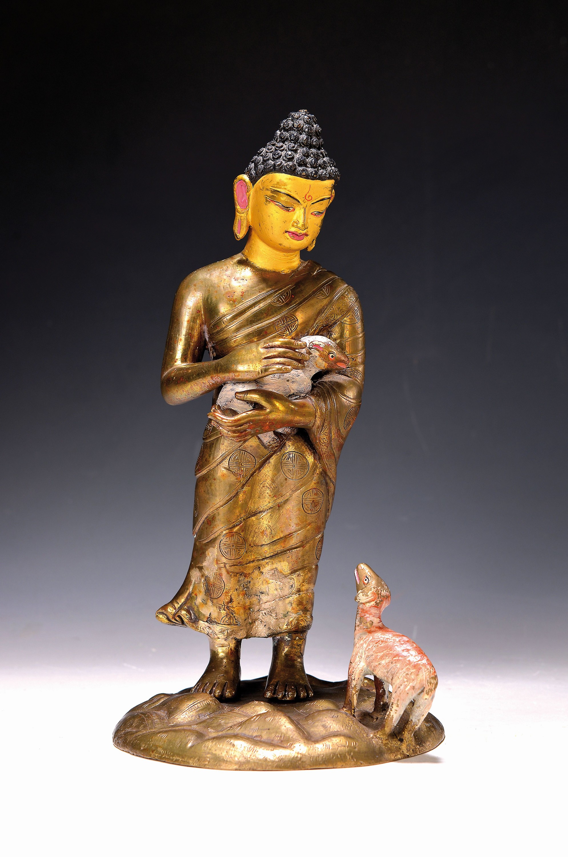 Buddha mit zwei Lämmern, Nepal, 20. Jh., Bronze, Lämmer und Gesicht und Haare bemalt, Reparaturstelle, H. ca. 30 cm
