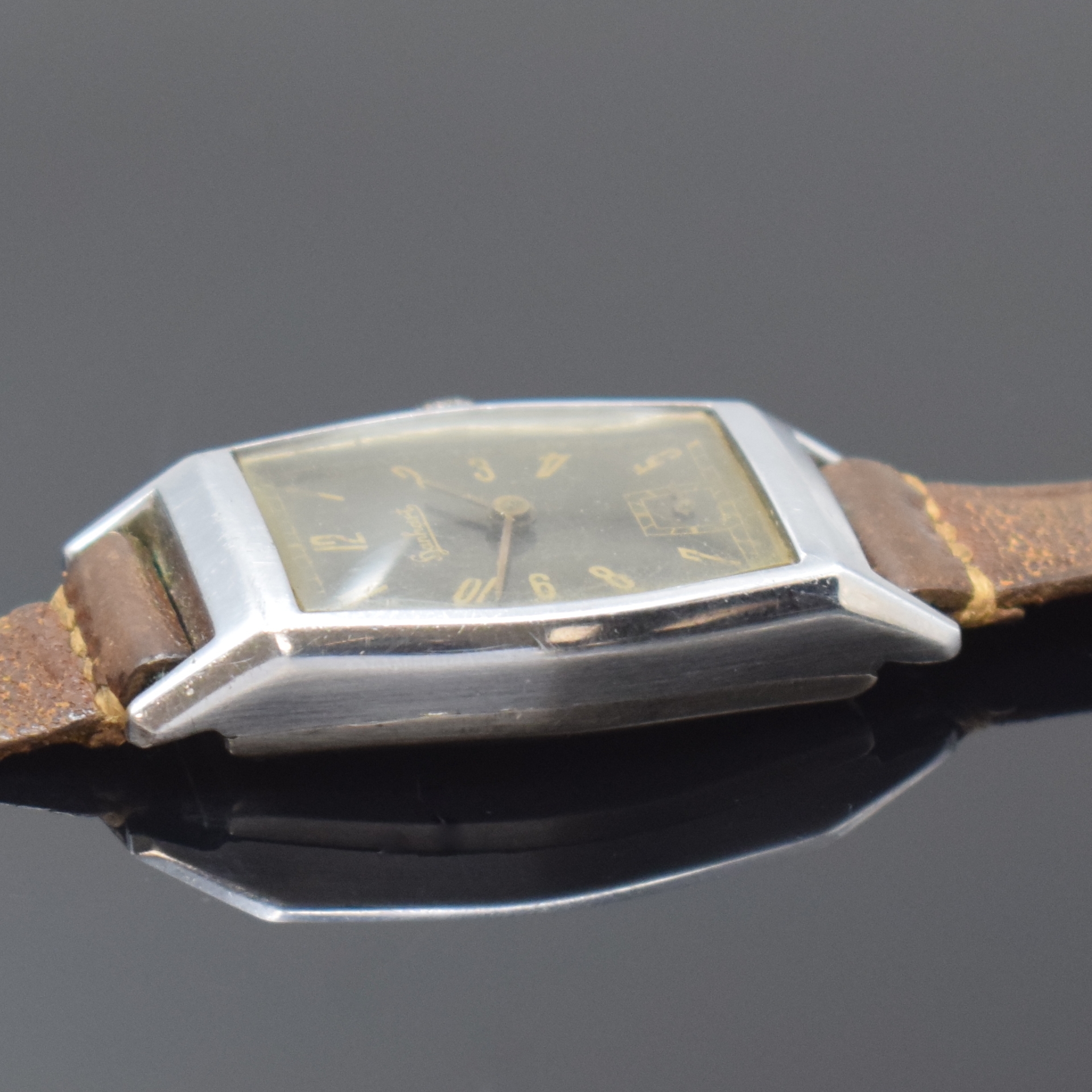 Detail b: HANHART Armbanduhr, 1930er Jahre, Handaufzug, Edelstahlboden aufgedr., schwarzes orig. Glanzblatt altersbed. fl./pat., tonneauförm. AH-Kal., 15 St., ...