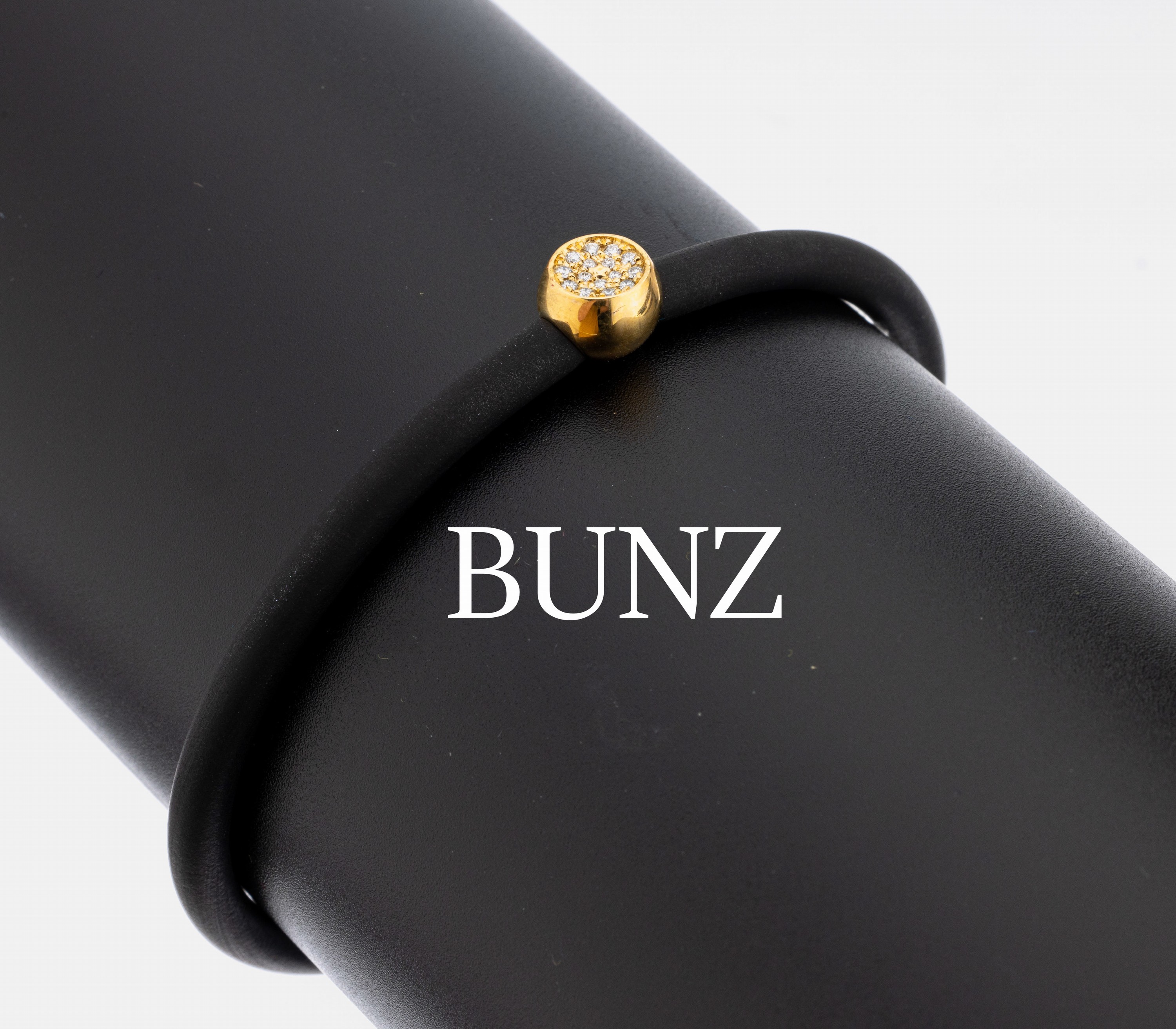 18 kt Gold BUNZ Brillant-Armreif, GG 750/000, schwarzes Kautschukband, schlichter Anhänger mit 15 Brillanten zus. ca. 0.10 ct (grav.) feines ...