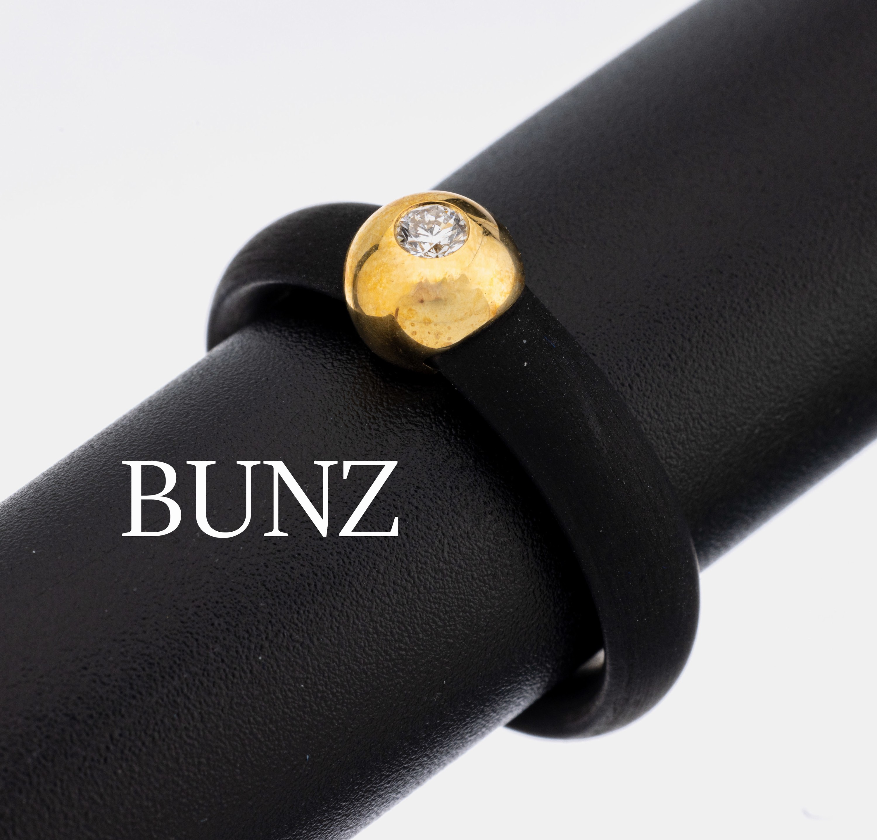 18 kt Gold BUNZ Brillant-Ring, GG 750/000, Ringschiene schwarzer Kautschuk, schlichter Kopf mit Brillant ca. 0.08 ct (grav.) feines Weiß/vs, RW 58, ...