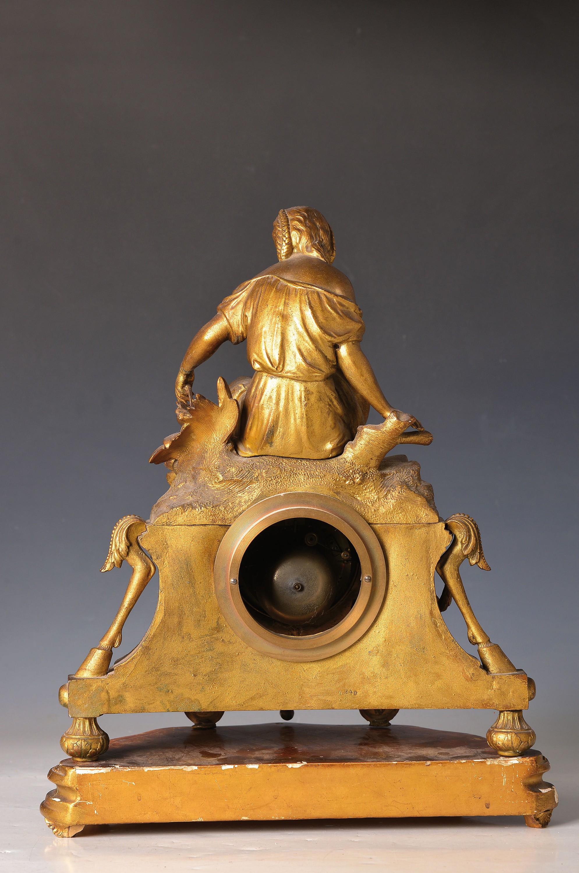 Detail e: Pendule, Frankreich um 1870, Bronzegehäuse, mit Figurenbekrönung mit Sockel, Frau mit Kanne, hintere Füsse verstellbar, mit alter Vergoldung ...