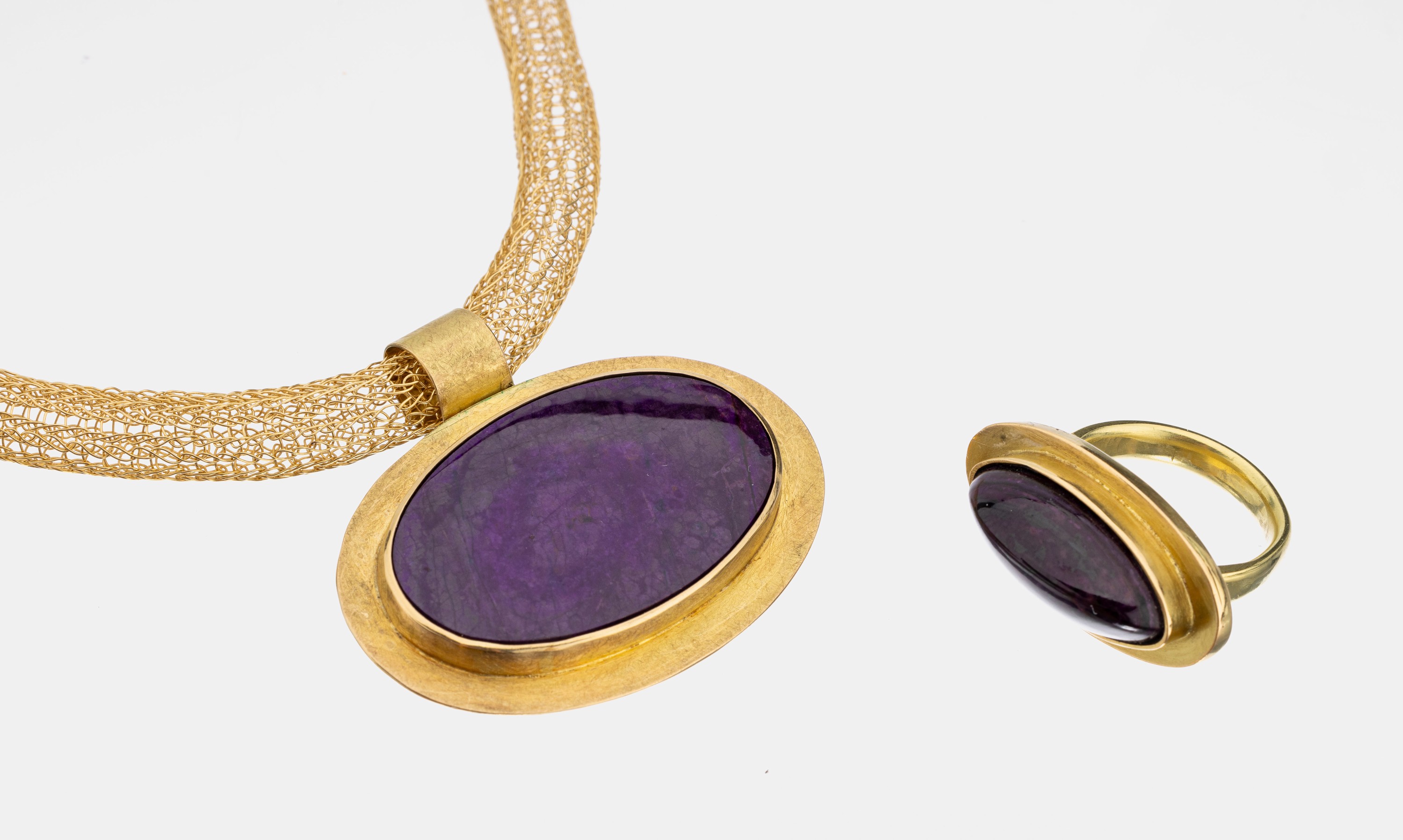 Gold Sugilith-Schmuckset, GG 750/000 und 585/000, best. aus: 18 kt Gold Anhänger mit ovaler Sugilith-Einlage, an fein geflochtenem 14 kt Gold ...