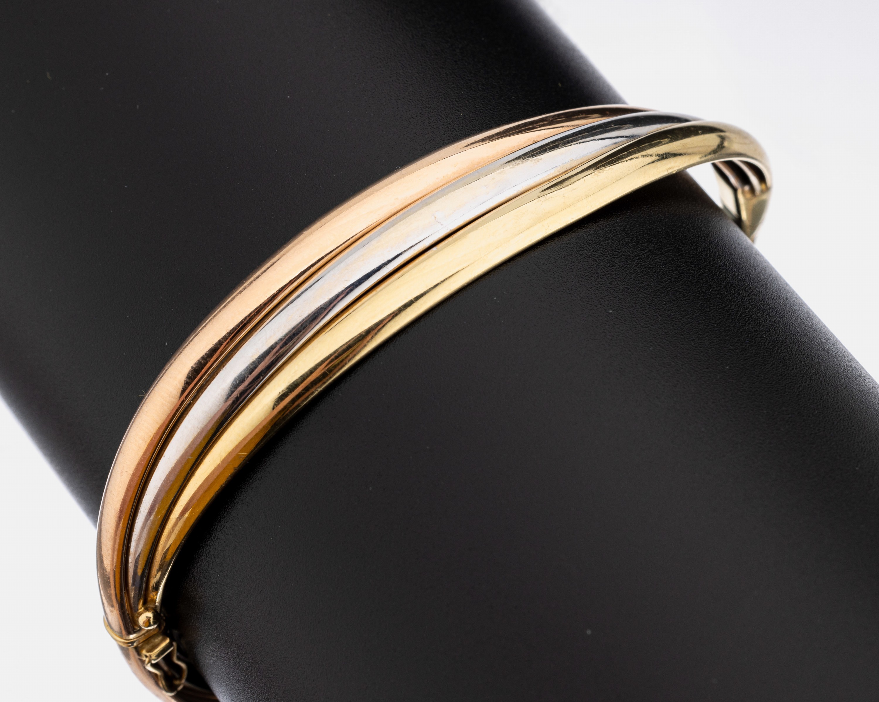 14 kt Gold Brillant-Armreif, GG/WG/RG 585/000, 3 in sich verschlungene Reife, mittlerer in WG bes. mit 15 Brillanten zus. ca. 0.30 ct Weiß/si, D. ...