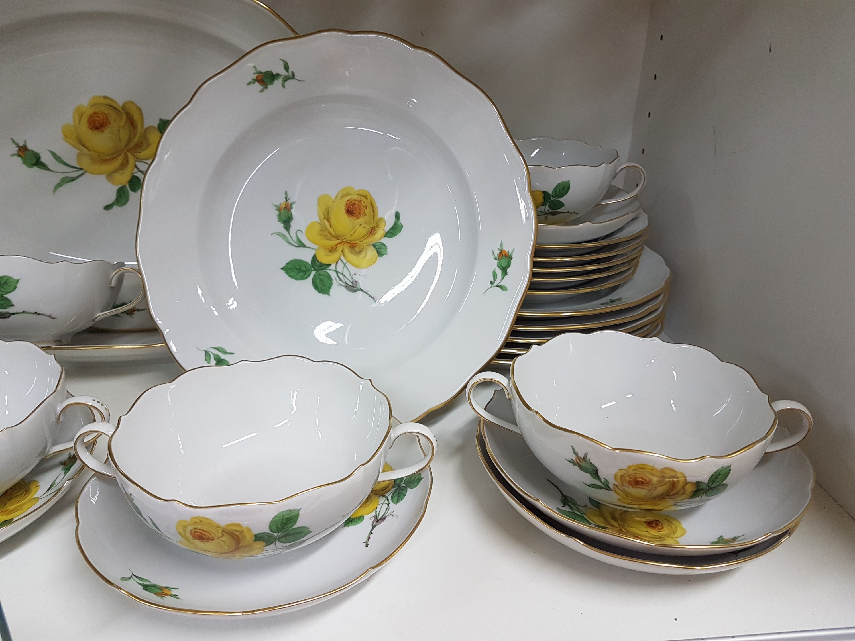 Detail c: Speiseservice für 6 Personen, Meissen, 20. Jh., 2. Wahl, Dekor gelbe Rose, Goldrand, 6 flache Teller, 6 Suppentassen mit Untertassen, 6 ...