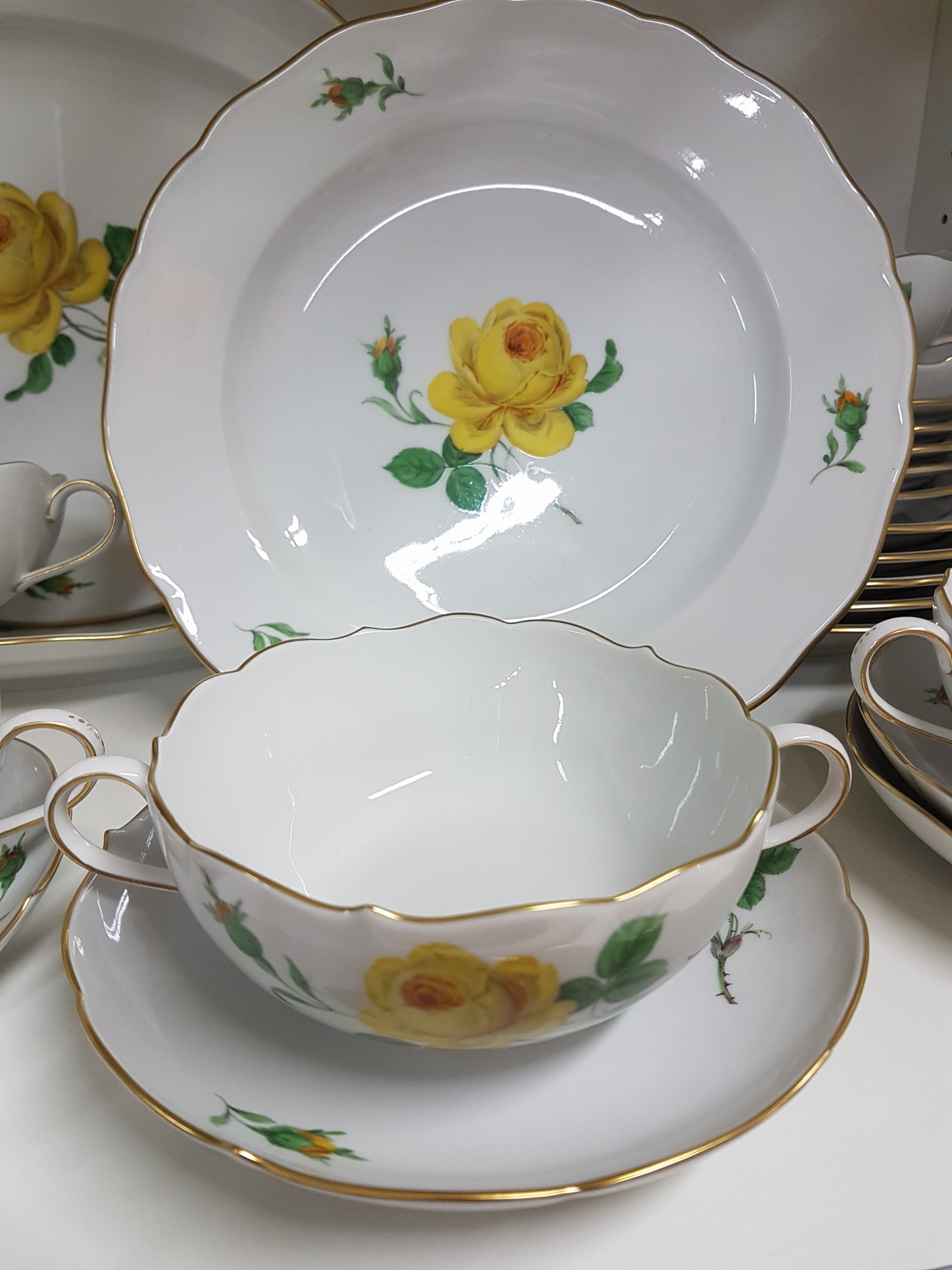 Detail d: Speiseservice für 6 Personen, Meissen, 20. Jh., 2. Wahl, Dekor gelbe Rose, Goldrand, 6 flache Teller, 6 Suppentassen mit Untertassen, 6 ...