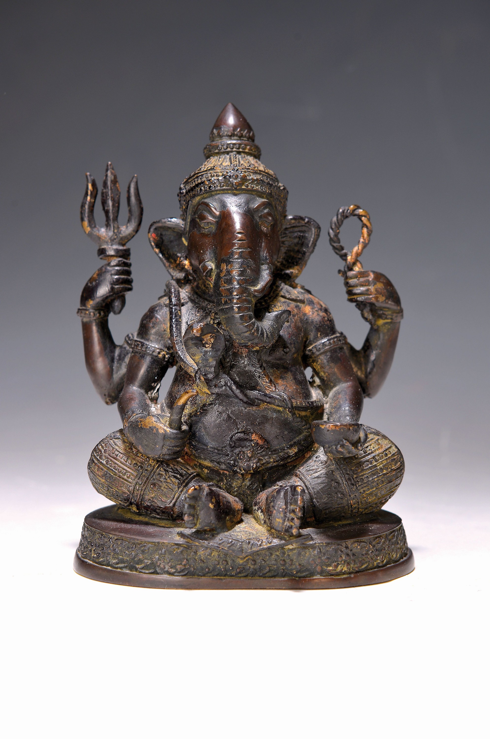 Skulptur der Gottheit Ganesha, Indien, um 1900, Bronze, ehemals teilvergoldet, vierarmige Darstellung mit Attributen, H. ca. 15cm