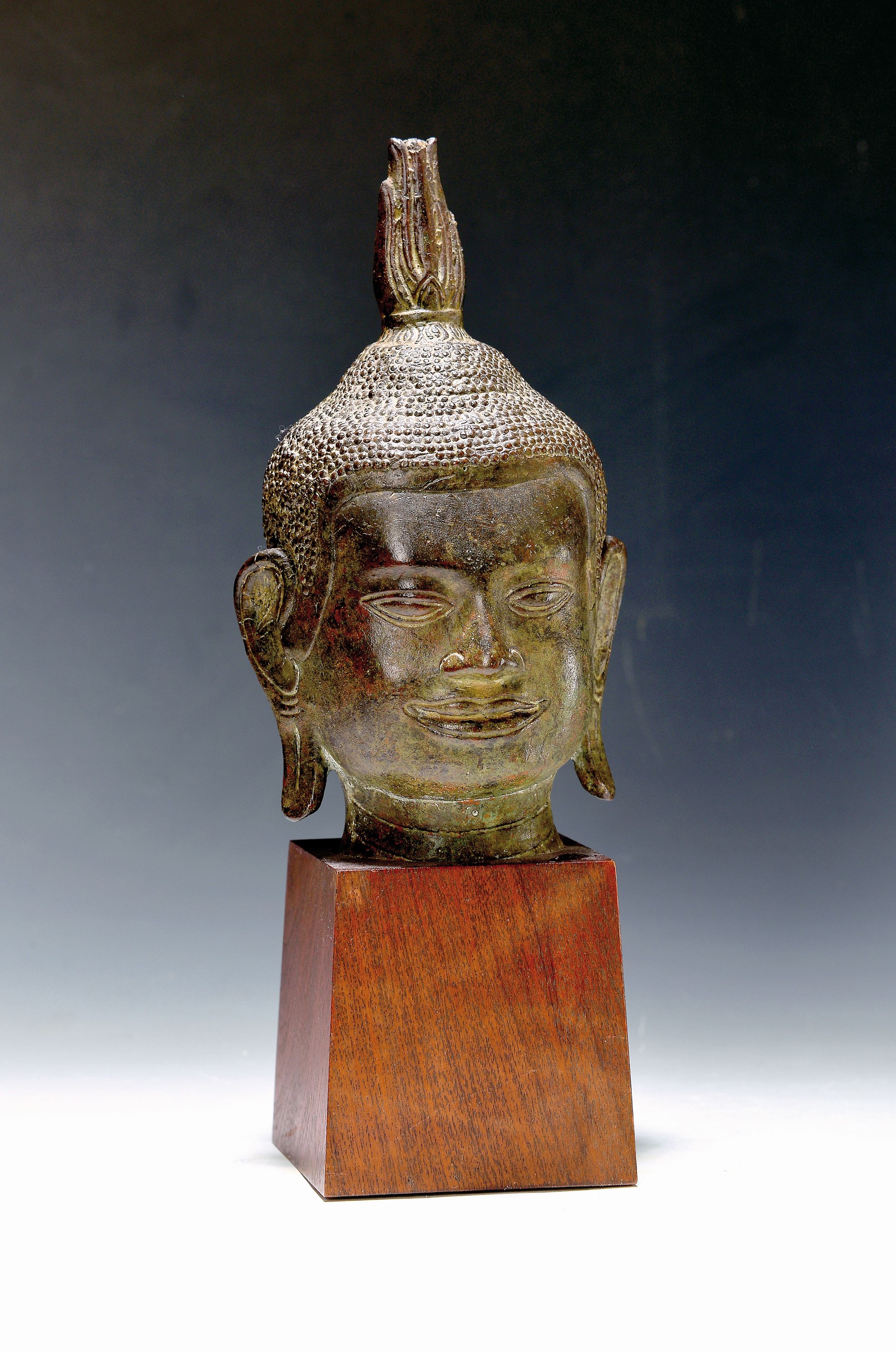 Buddhakopf, Thailand/Burma, wohl 18. Jh., Bronze, Flamme leicht bestoßen, auf Holzsockel, lange Ohren, feiner Guß, schöne Patina, ca. 22 cm, ...