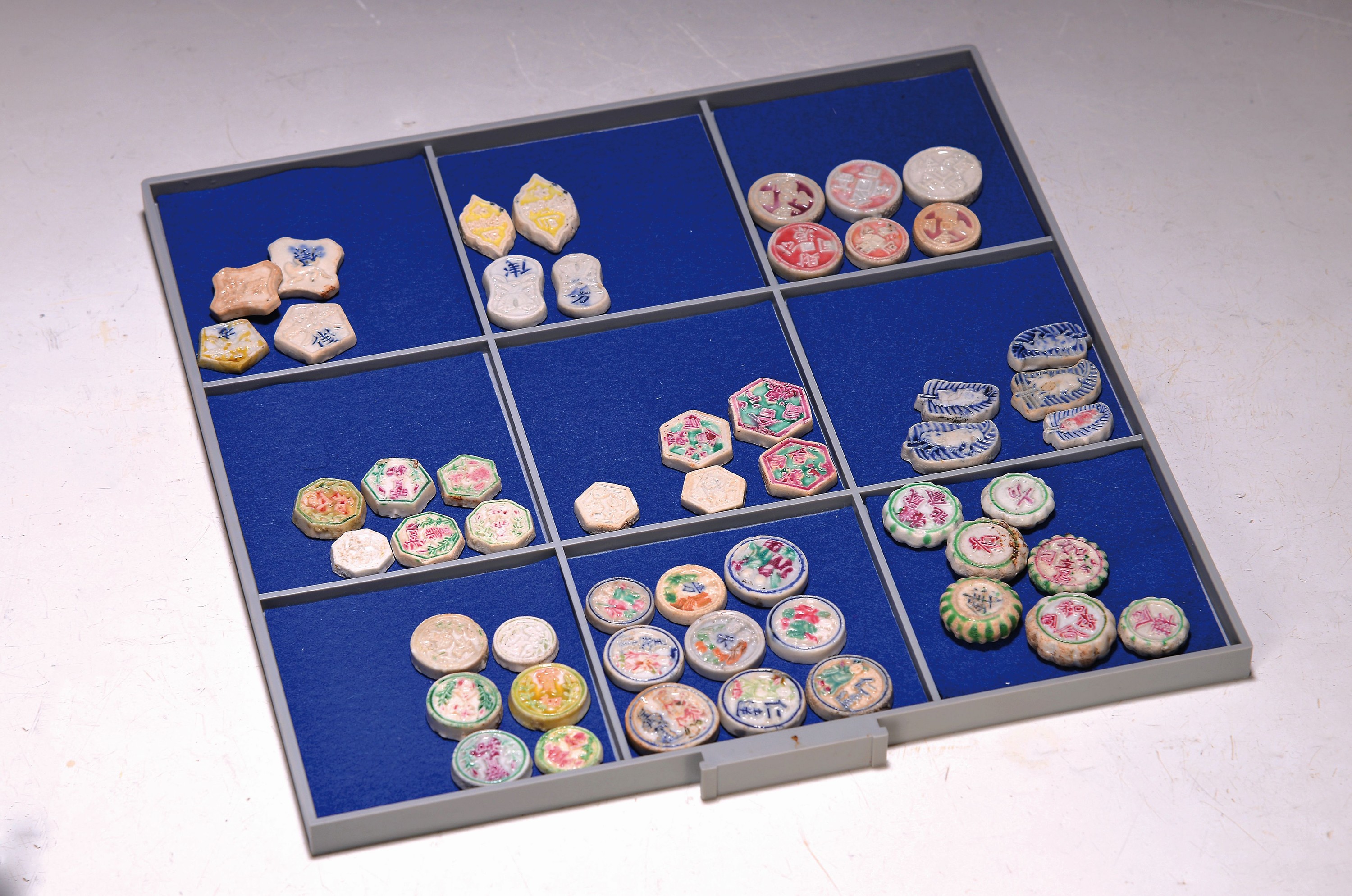 52 Token/Spielsteine/Jetons, Asien, Porzellan, 20. Jh., versch. Formen, teilweise Dekoration mit Figuren, Schriftzeichen, Tiere etc., meist bunt oder ...