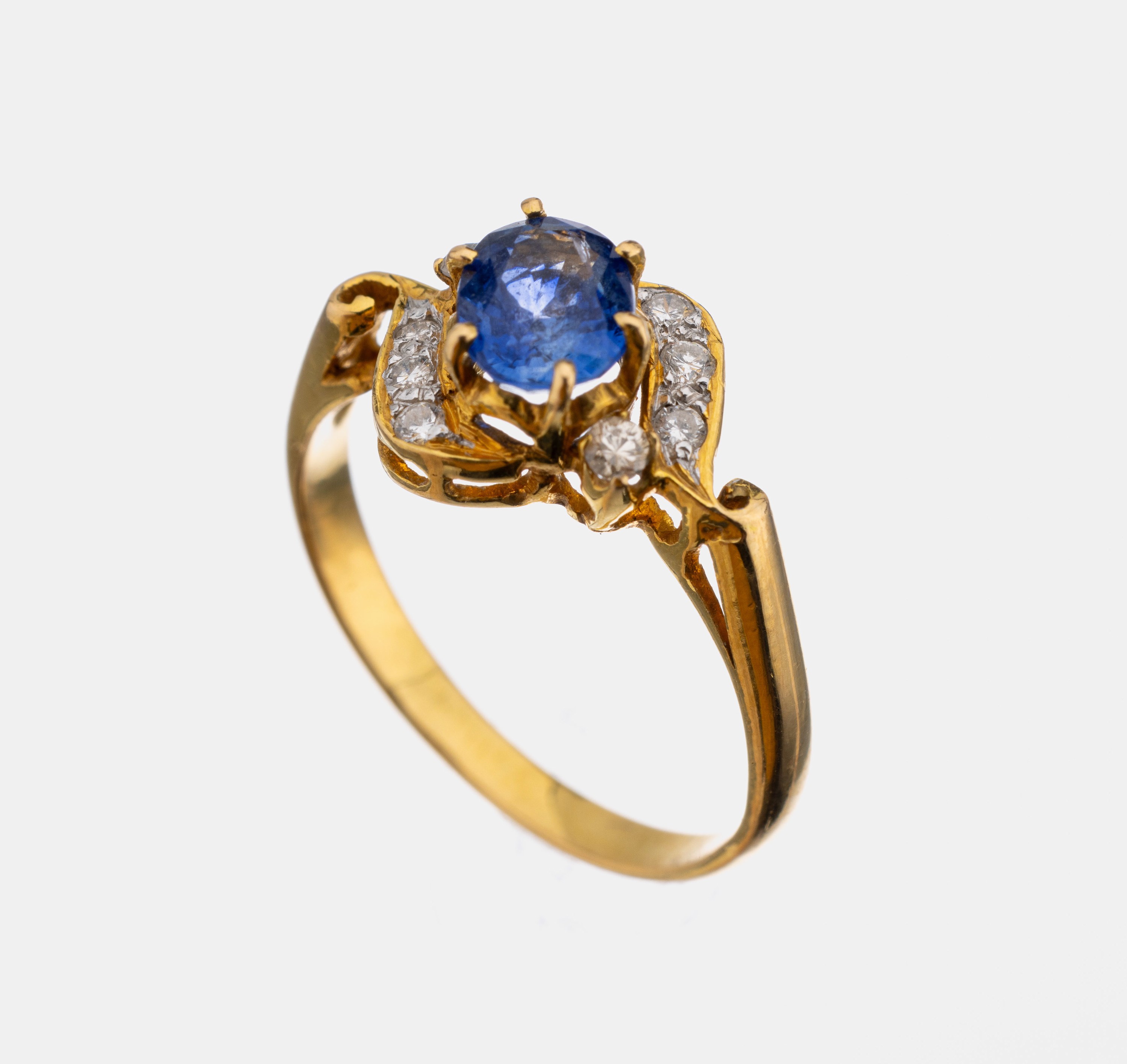 18 kt Gold Saphir-Brillant-Ring, GG 750/000, mittig ovalfacett. Saphir ca. 1.00 ct, umgeben von 8 Brillanten zus. ca. 0.18 ct Weiß/p, RW 53, ca. ...