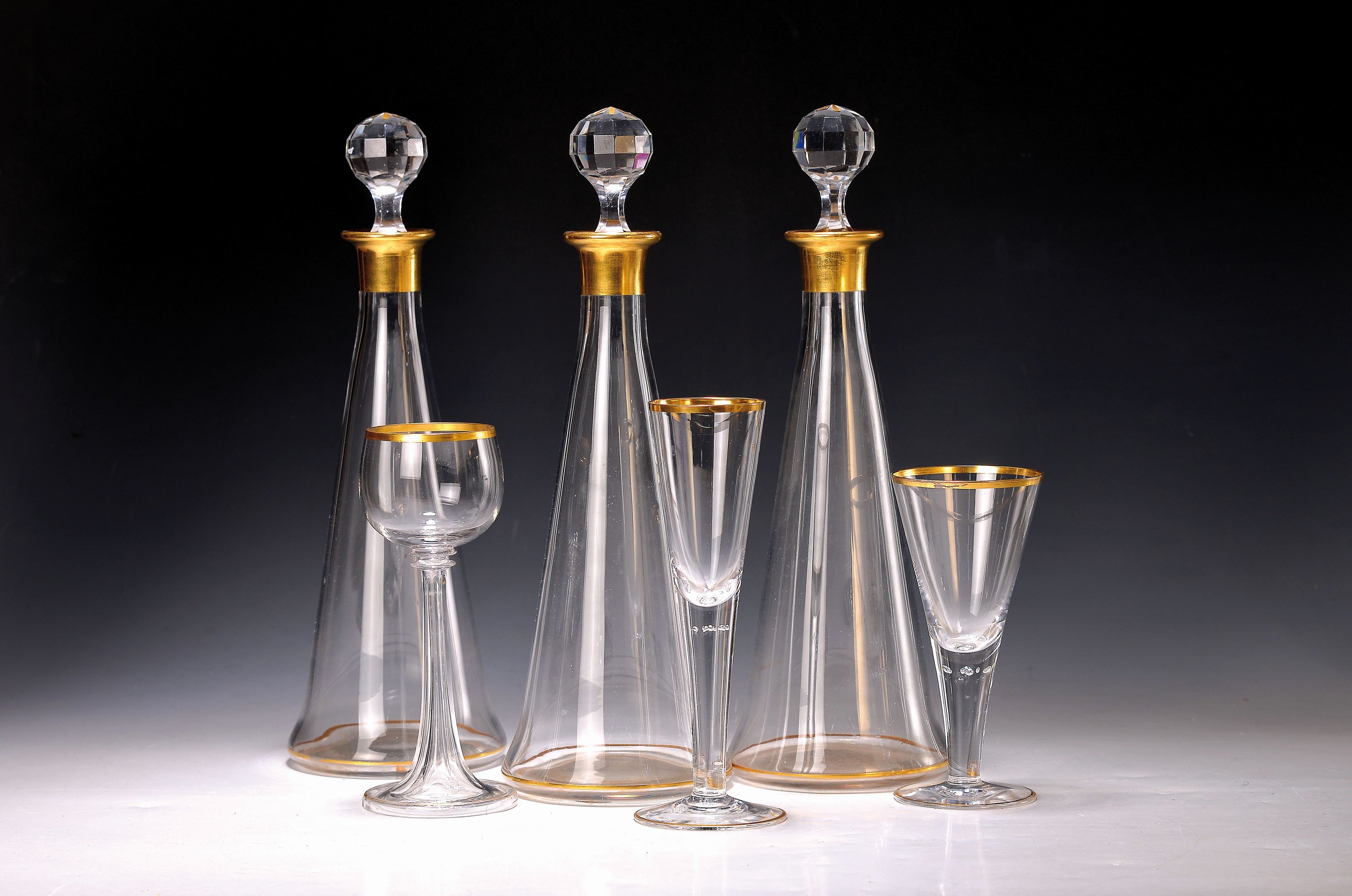 14 Trinkgläser und drei Karaffen, deutsch, um 1900/10, farbloses Glas, 8 Weingläser mit facettierten Hohlfüssen, 4 Weingläser mit eingestochenen ...