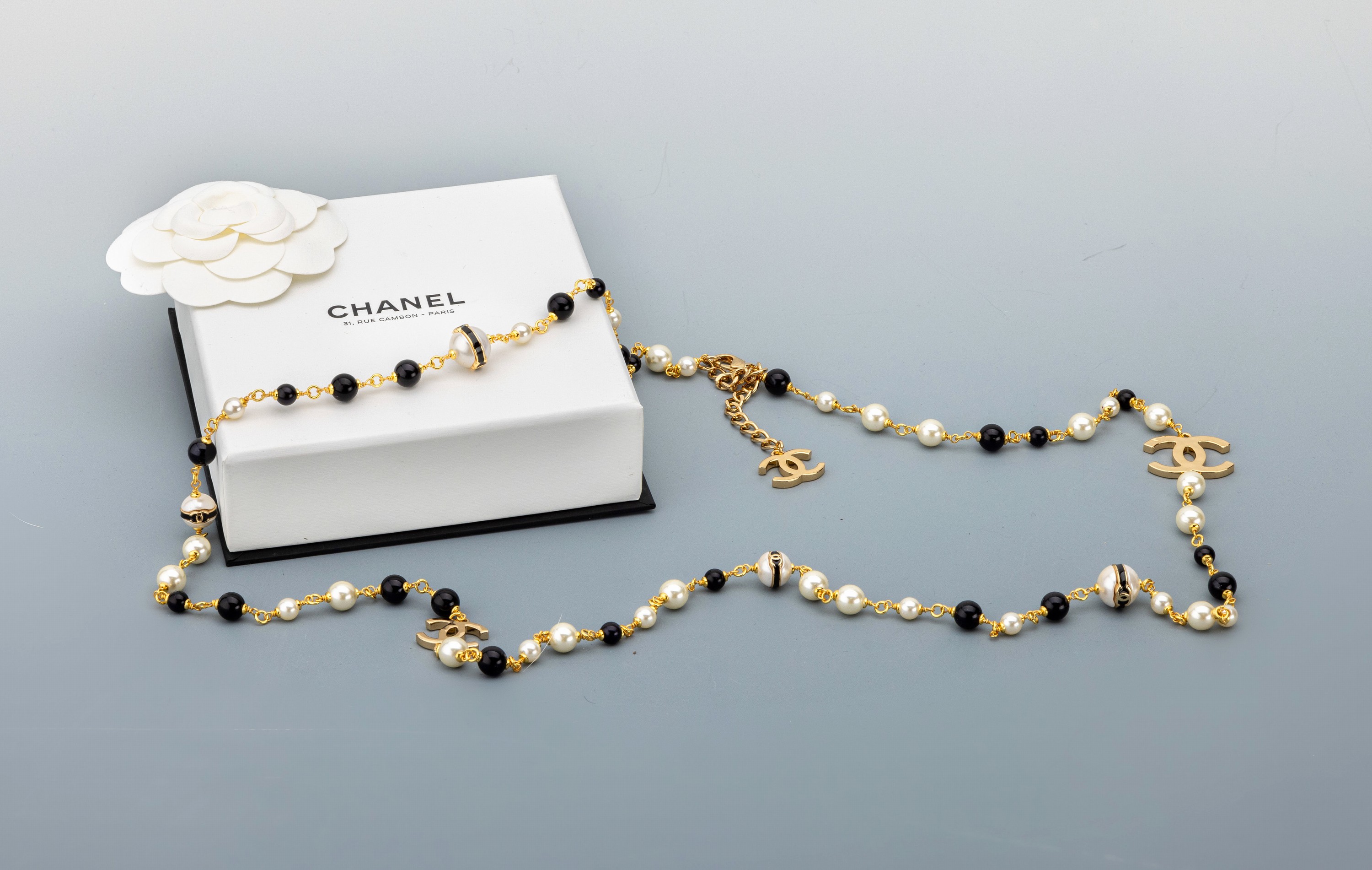 Langes CHANEL Modeschmuck-Collier, Paris, Metall verg., weiße Kunstperlen, schwarze Harzperlen, ca. 6 - 8 mm, CC-Embleme, L. ca. 100 cm, ...