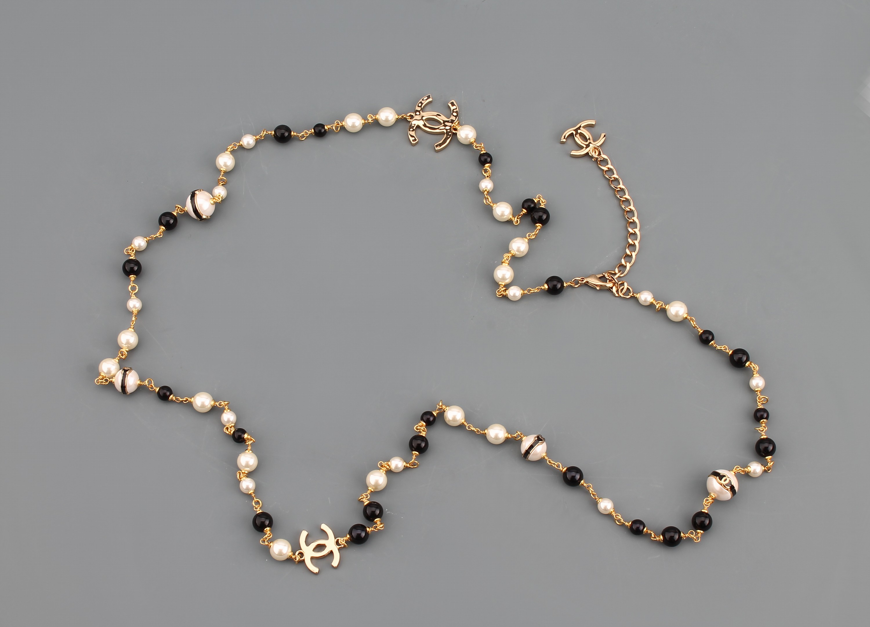 Detail b: Langes CHANEL Modeschmuck-Collier, Paris, Metall verg., weiße Kunstperlen, schwarze Harzperlen, ca. 6 - 8 mm, CC-Embleme, L. ca. 100 cm, ...