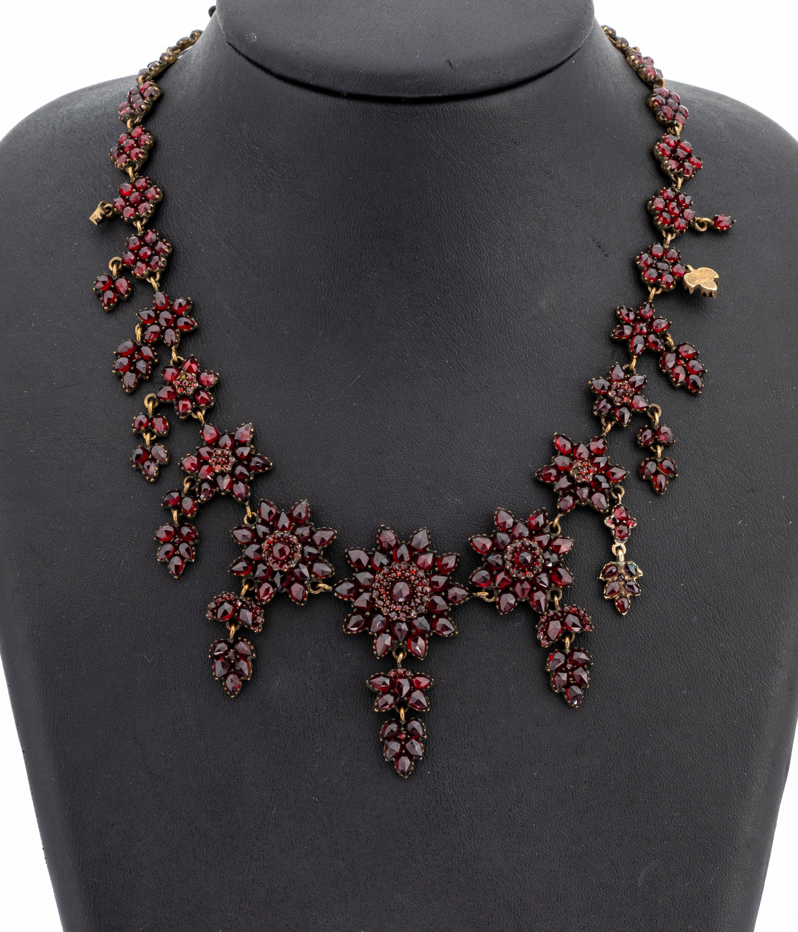 Granat-Collier, Böhmen um 1880/90, Tombak verg., facett. Granate von intensiver Farbe, blütenförm. Elemente, bewegl. Abhängungen, L. ca. 50 cm, ...