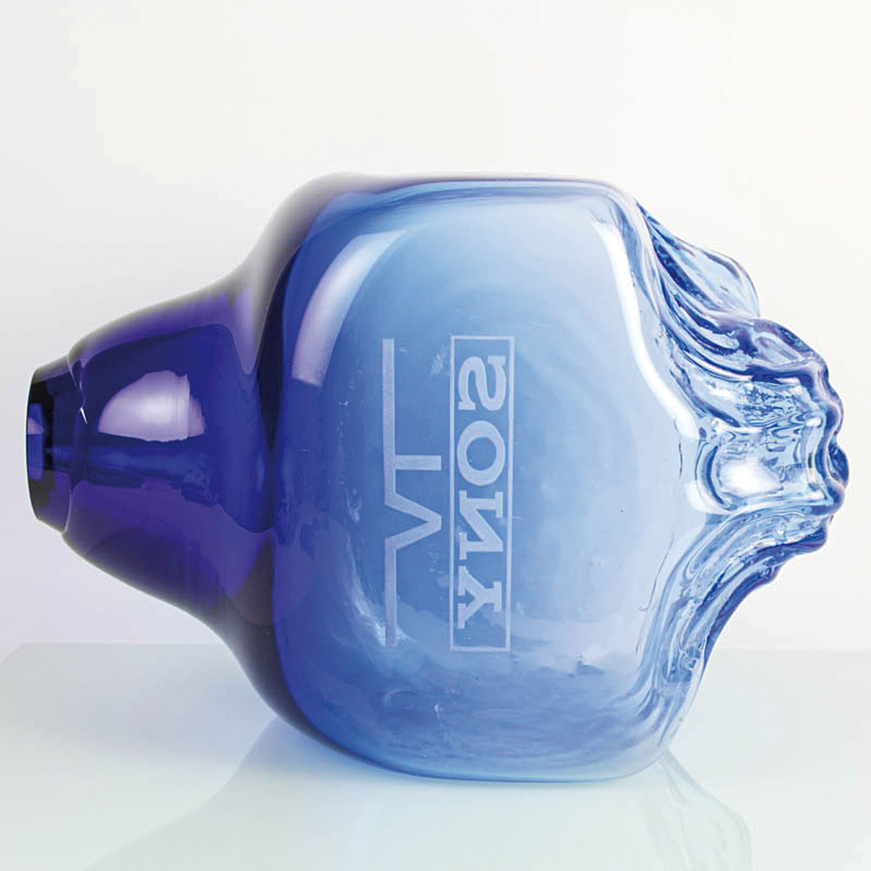 Detail e: Glasobjekt bzw. Werbeobjekt, signiert Sprachalova, 1997, farbloses Glas mit blauenEinschmelzungen, Reliefdekor eines Löwenkopfes, verso mit ...