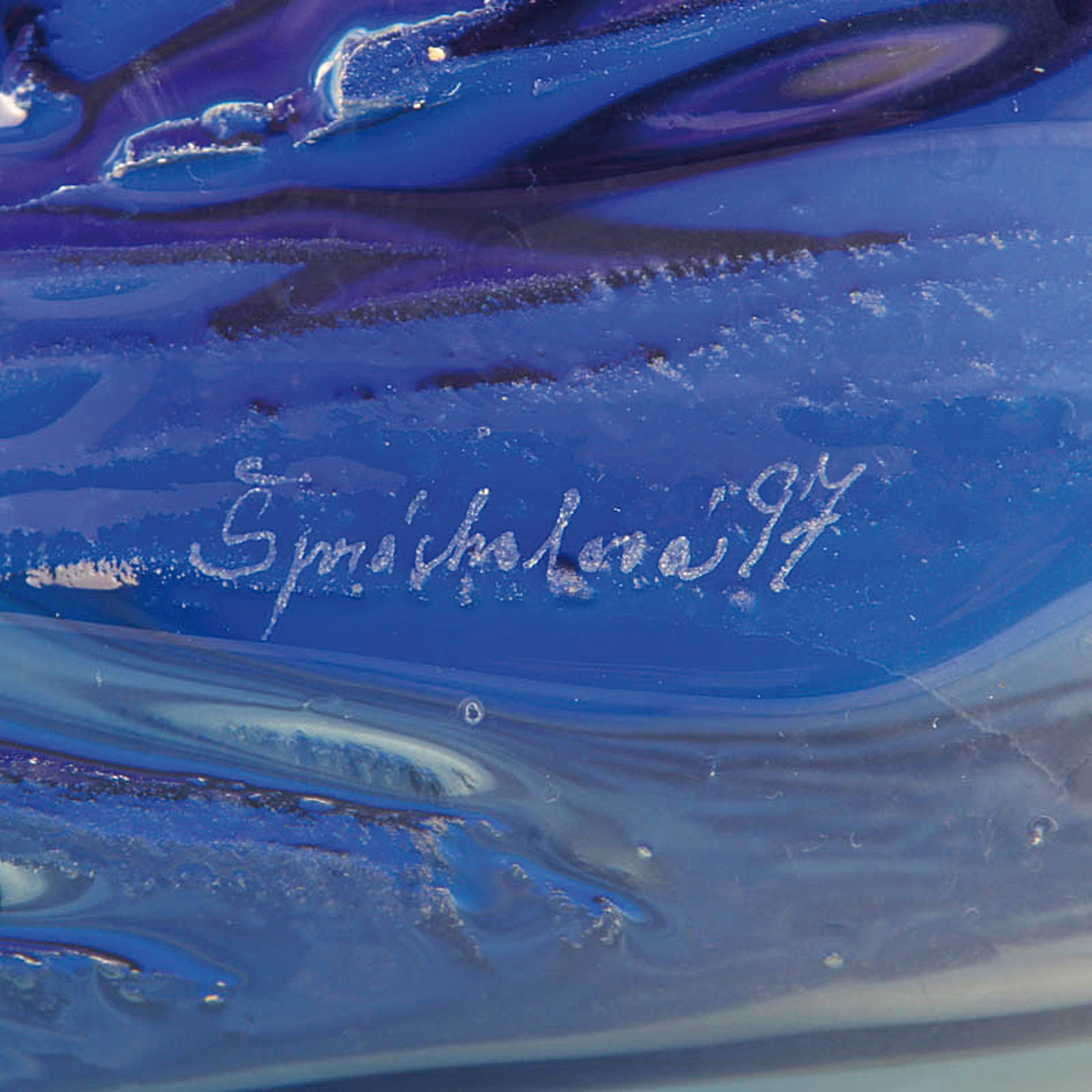 Detail g: Glasobjekt bzw. Werbeobjekt, signiert Sprachalova, 1997, farbloses Glas mit blauenEinschmelzungen, Reliefdekor eines Löwenkopfes, verso mit ...