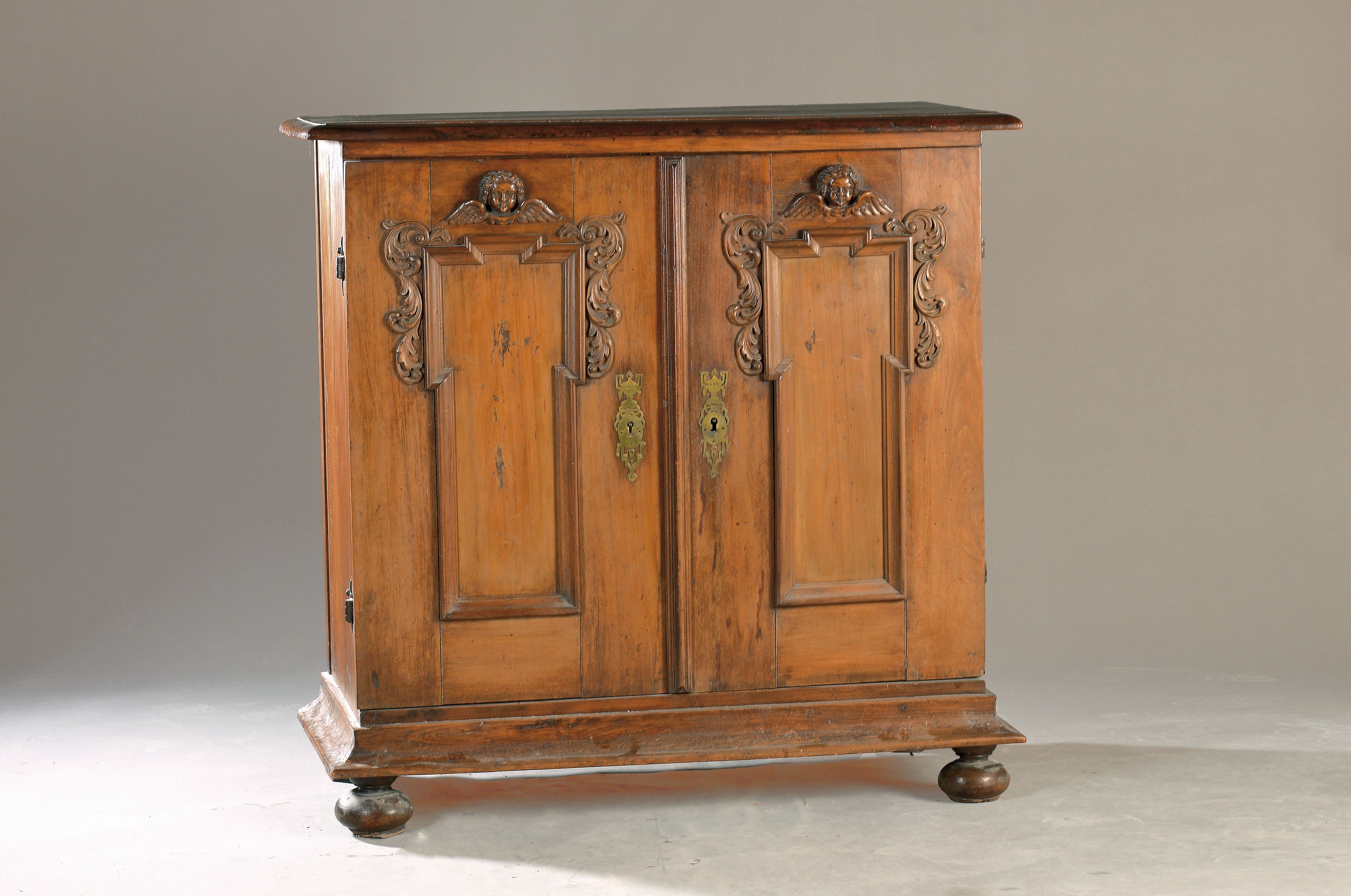 Halbschrank, um 1880, Nussbaum massiv, z.T. Furnier, aufgelegte Schnitzereien von Puttenköpfen, zweitürig, Türen auf Rahmen gearbeitet, ca. ...