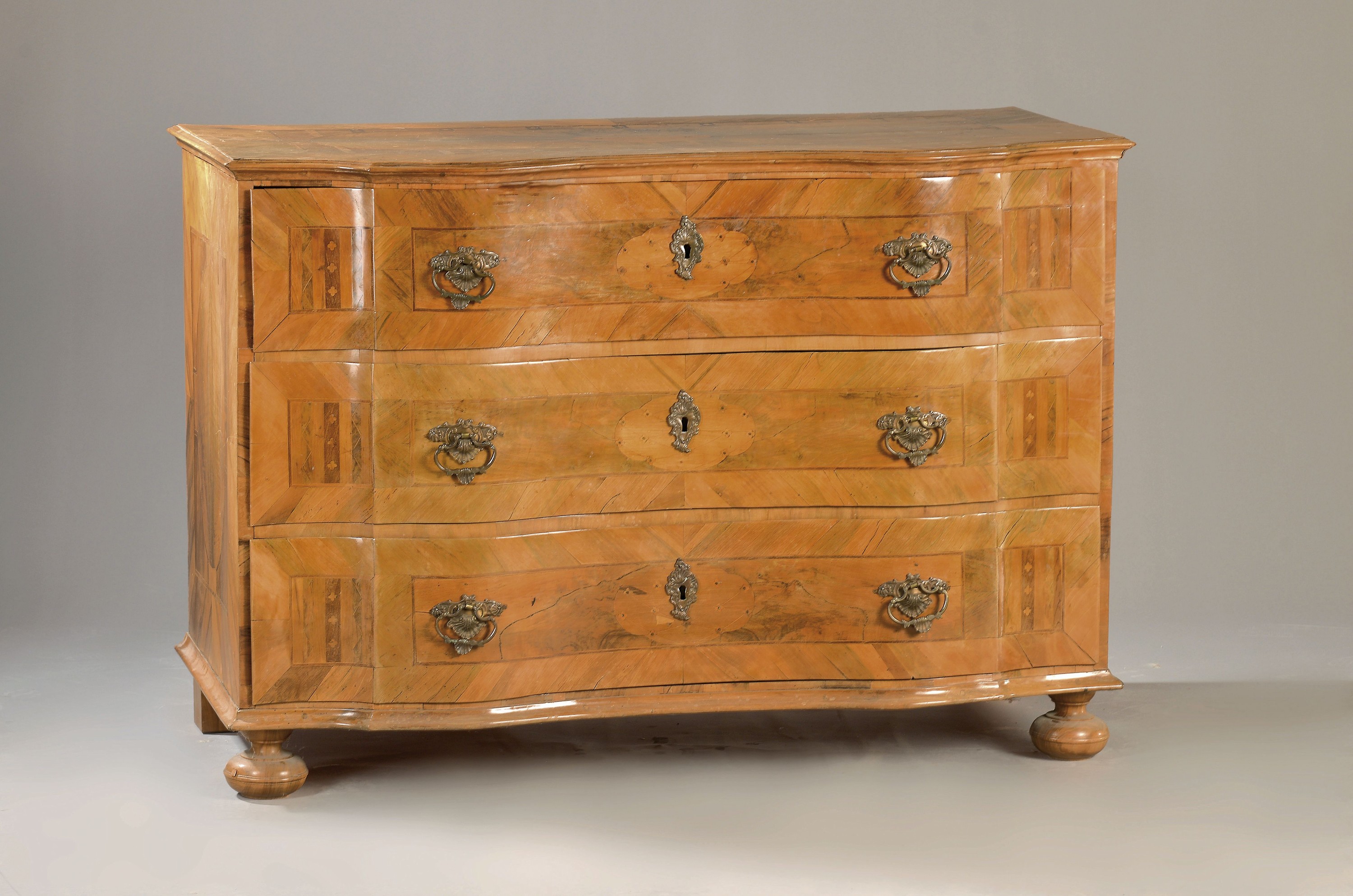 Barock-Kommode, um 1750, Nußbaumfurnier, 3 Schubladen, intarsiert, geschweifte Form, Messingbeschläge, ca. 85 x 122 x 63 cm, EZ 2-3