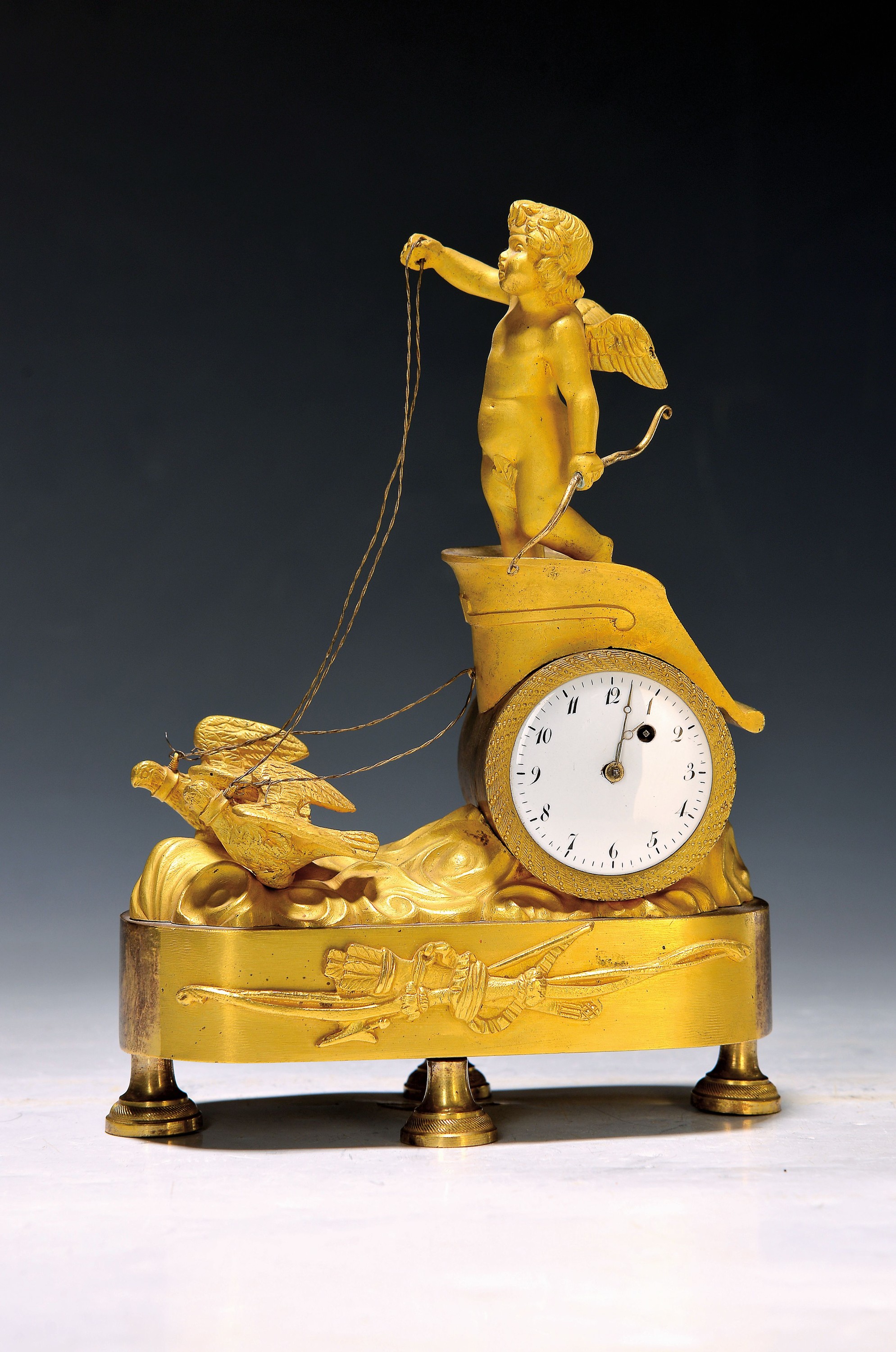 Miniatur-Pendule, Empire, Frankreich Anfang 19. Jh., verziertes Bronzegehäuse auf vier Füßen stehend, im Sockel Symbolik des Amor mit Bogen und ...