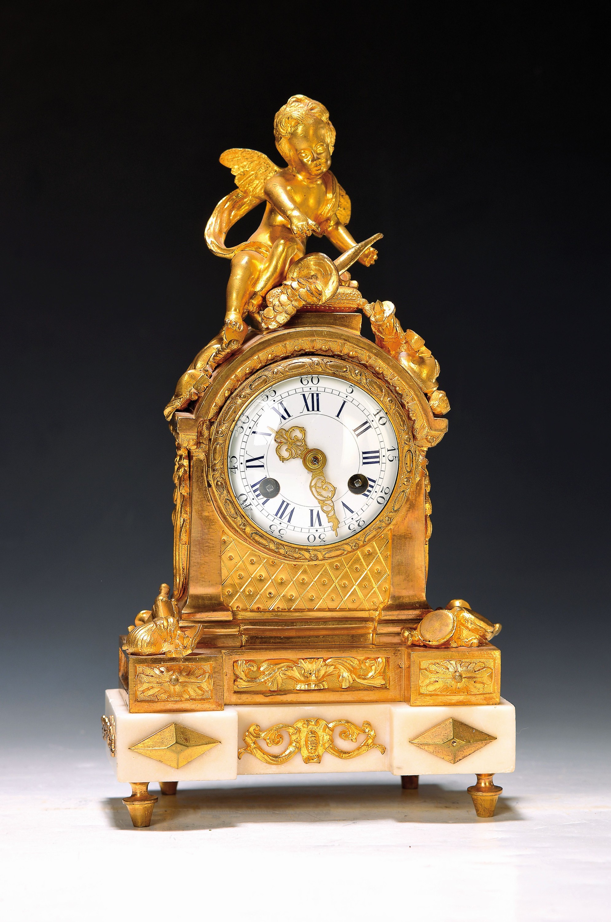 Kleine Pendule, Frankreich um 1900, weißer Marmorsockel, Bronze verziert mit alter Feuervergoldung, Thematik Musik, allseitig mit Musik Instrumenten ...