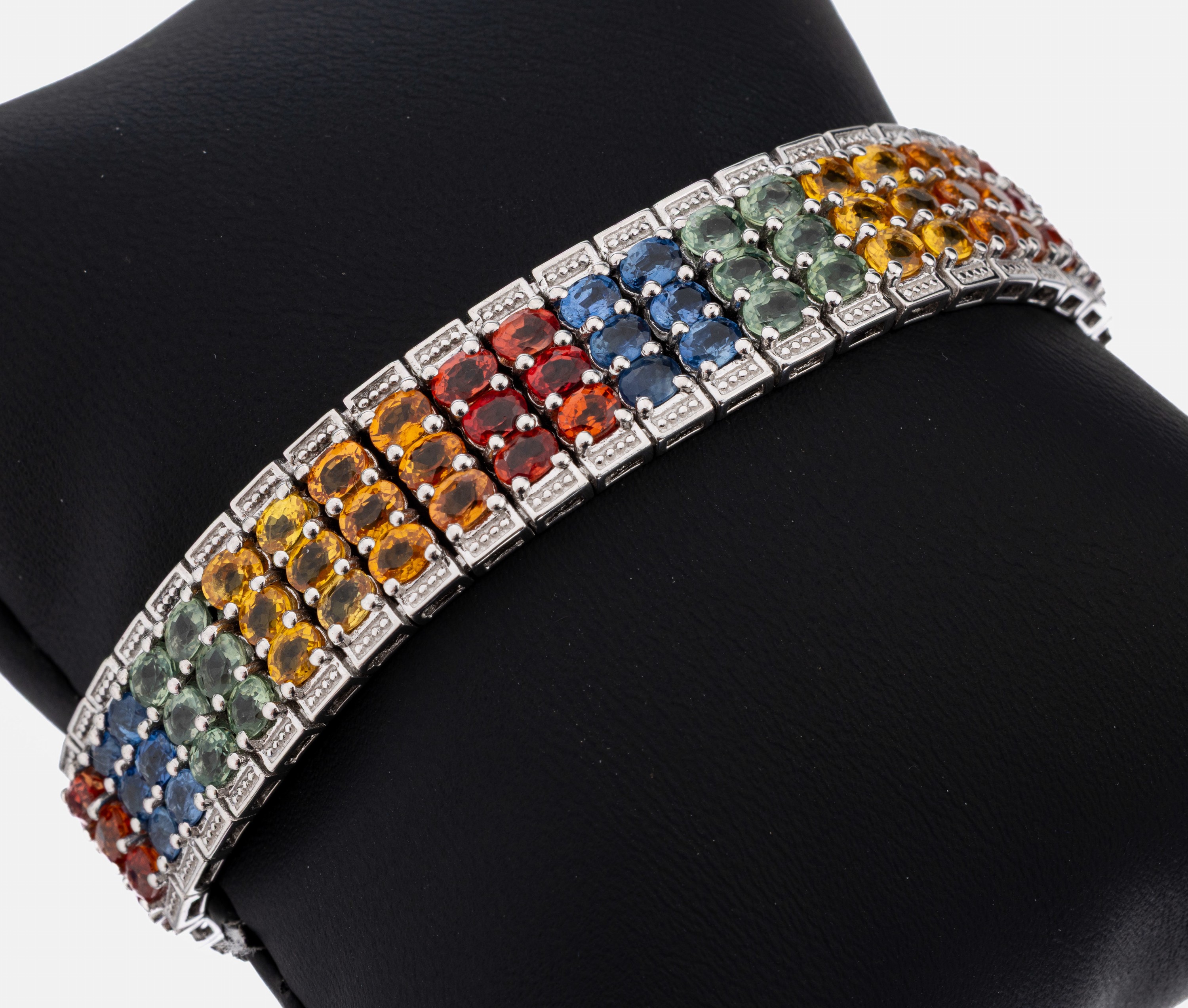 Saphir-Armband, Silber, 134 ovalfacett. Saphire in Blau, Grün, Gelb und Orange zus. ca. 25.00 ct, B. ca. 1 cm, L. ca. 19 cm, Kastenschloss mit 2 ...