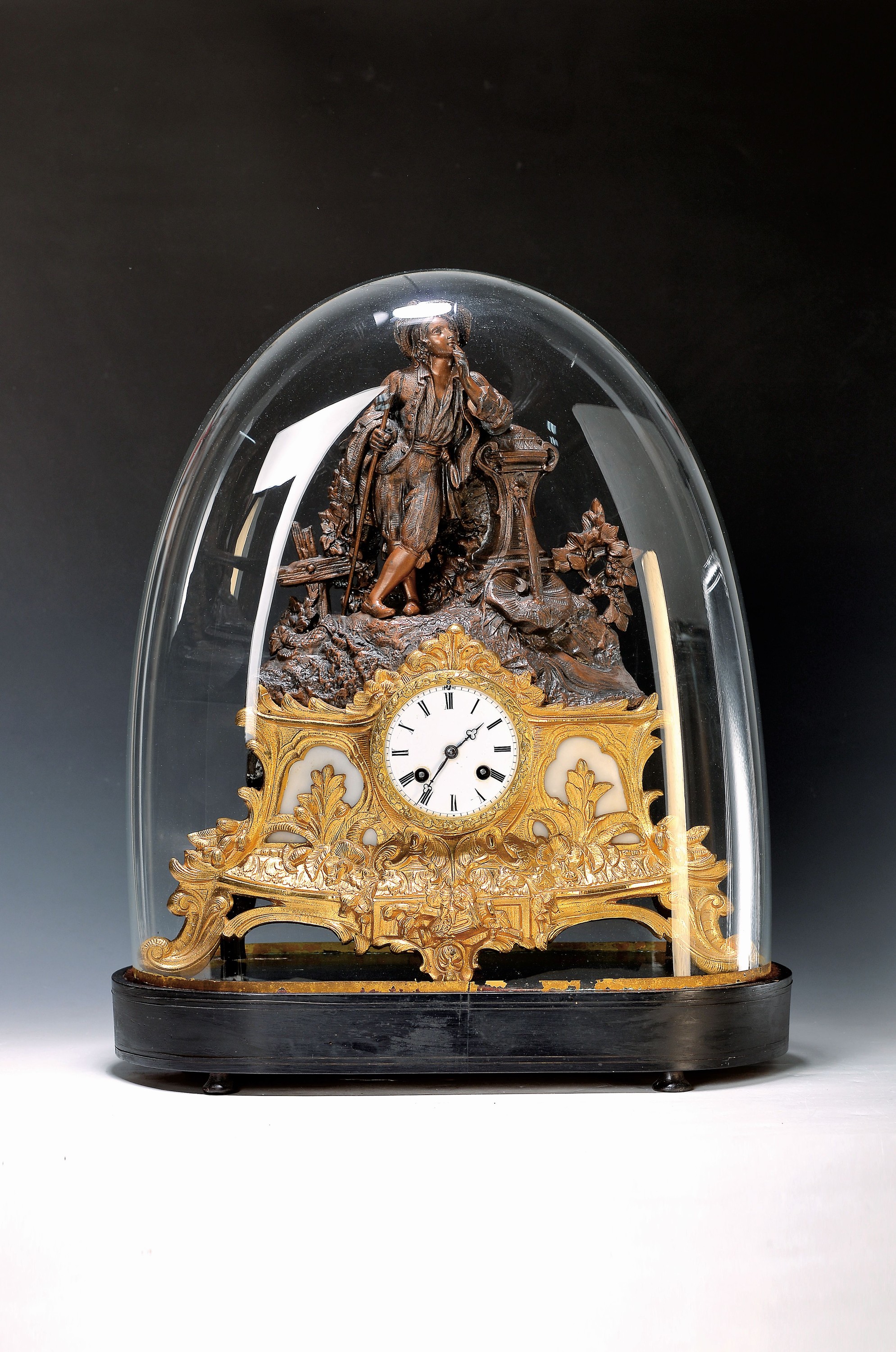 Pendule mit Glasdom, Ende 19.Jh., ovaler profilierter Holzsockel, Regulle Gehäuse mit alter Vergoldung, Alabastereinlagen, Rückseitig Metall/Füße ...