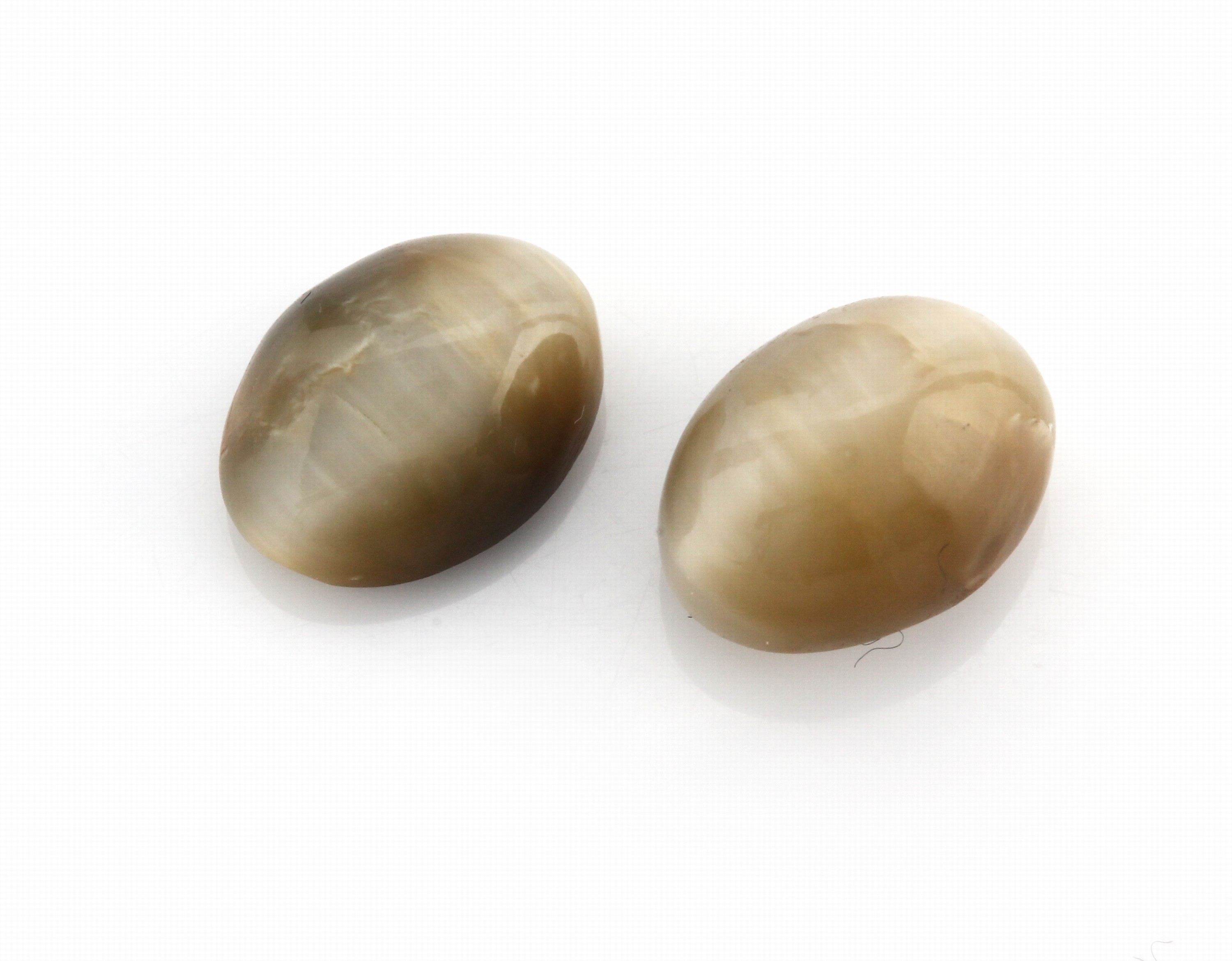 Lot 2 lose ovale Katzenaugencabochons, zus. 10.66 ct, ca. 1 x 0.7 cm, 1.2 x 0.9 cm