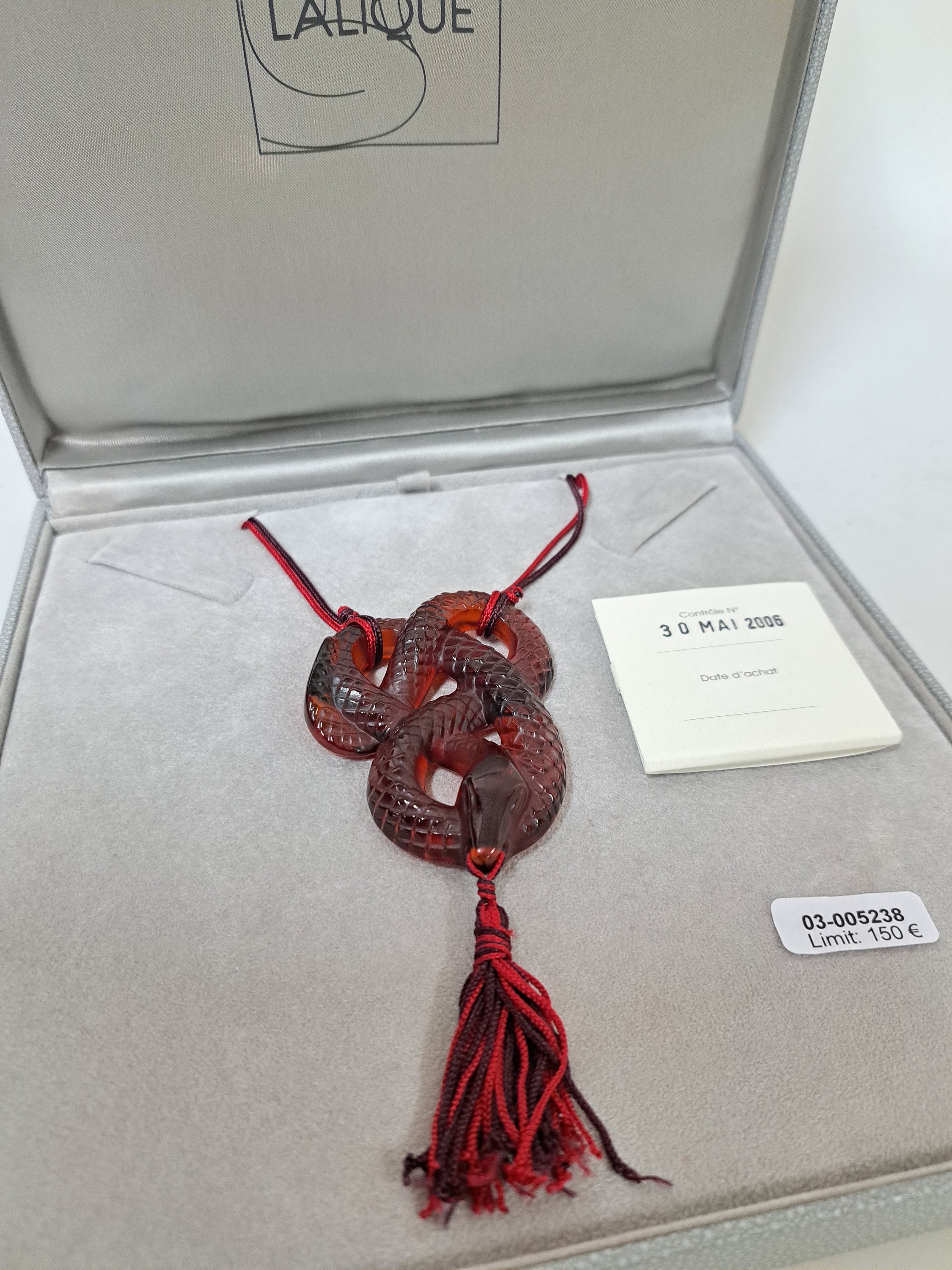 Detail a: Collier Serpent Rouge, Lalique, 20.Jh., rotes Kristallglas in Form einer vielfach gewunden Schlange, z.T. strukturiert, rot- schwarze Seidenquaste im ...