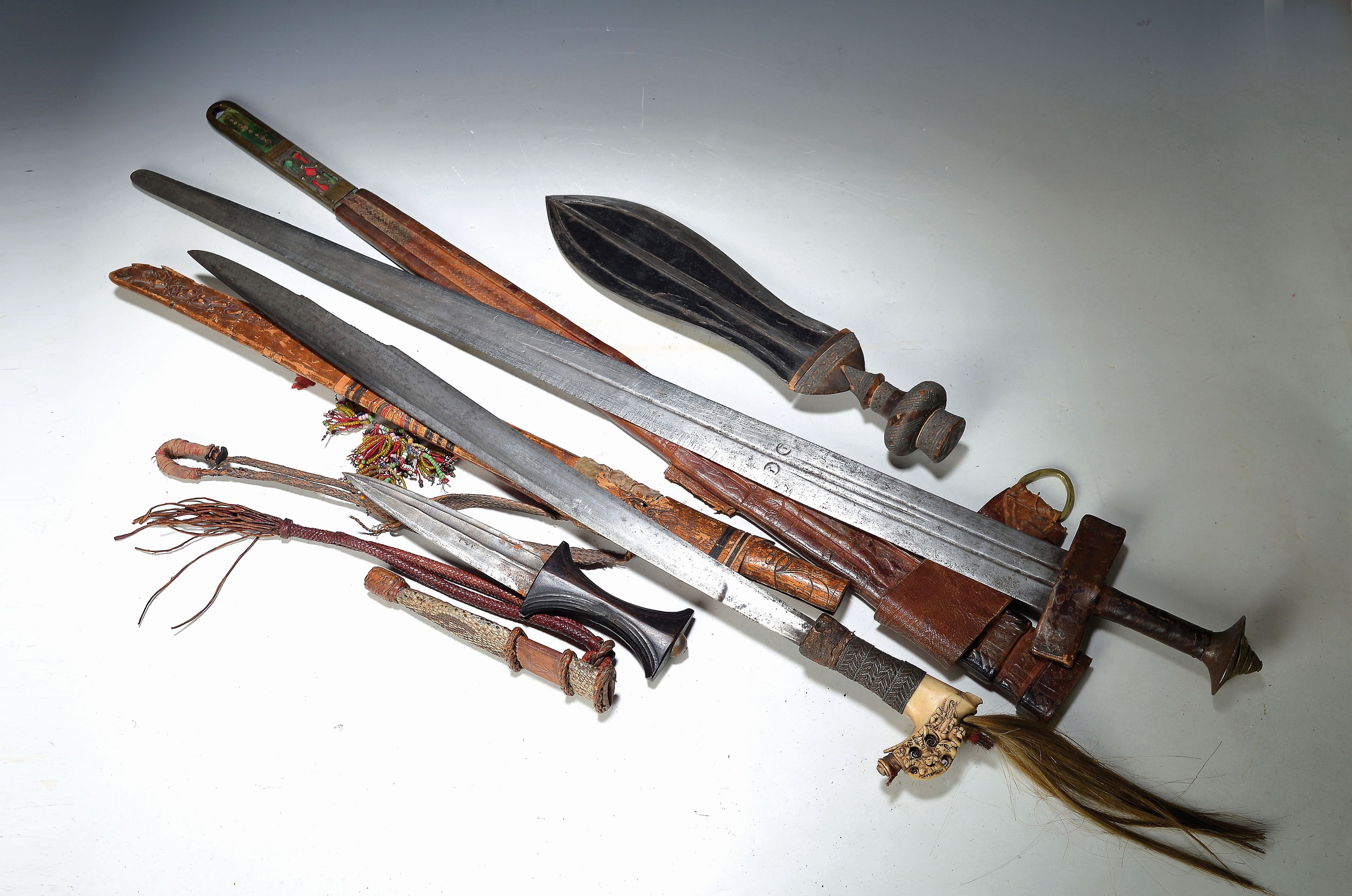 Zwei Schwerter, Dolch und Messer, Stammeskunst, Nordafrika/Borneo, 20. Jh., Schwert mit Lederscheide, wohl Tuareg, L. 97 cm, Schwert mit mit ...