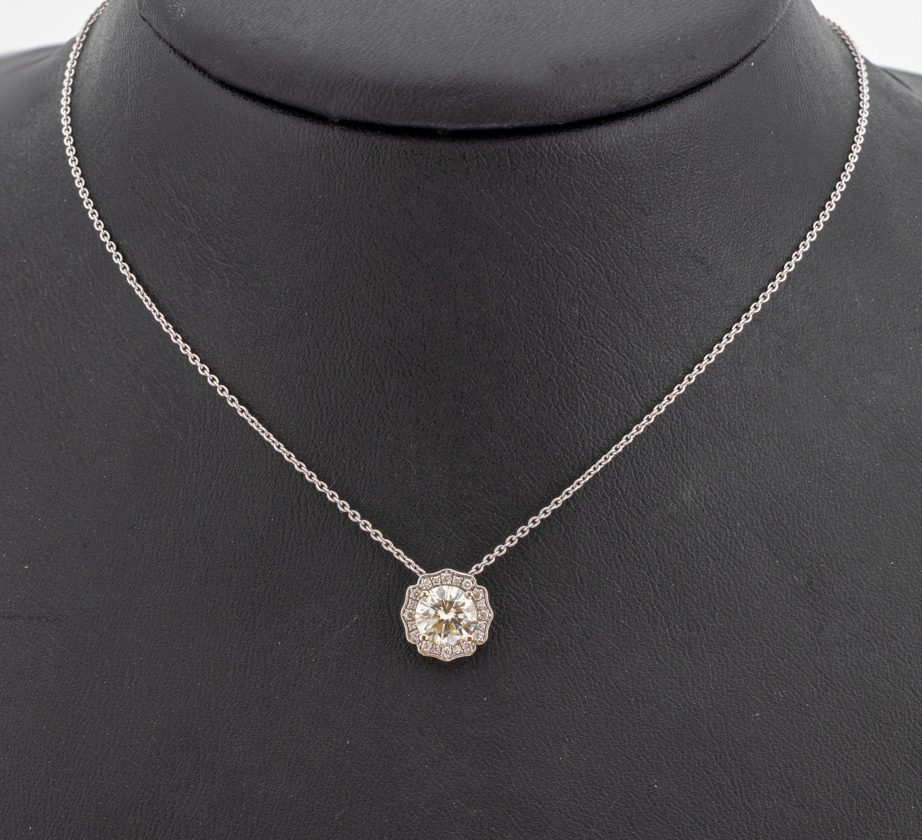 18 kt Gold Brillant-Collier, WG 750/000, Brillant ca. 1.01 ct l.get.Weiß/vs, umgeben von Brillanten zus. ca. 0.10 ct feines Weiß-Weiß/vs-si, L. ...
