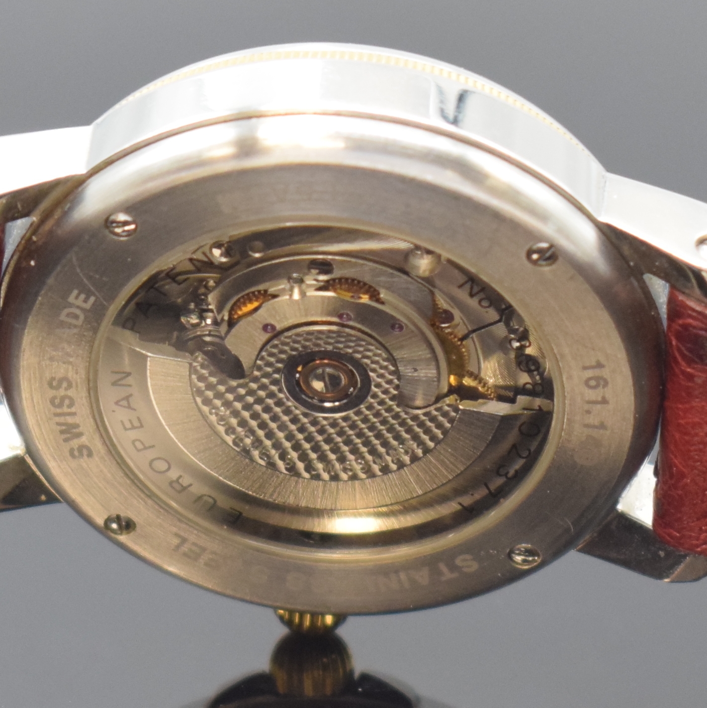Detail e: JEAN MARCEL Herrenarmbanduhr mit wandernder springender Stunde, Schweiz um 1995, Automatik, beids. vergl. Geh. in Stahl, Boden 4-fach verschr., Krone ...