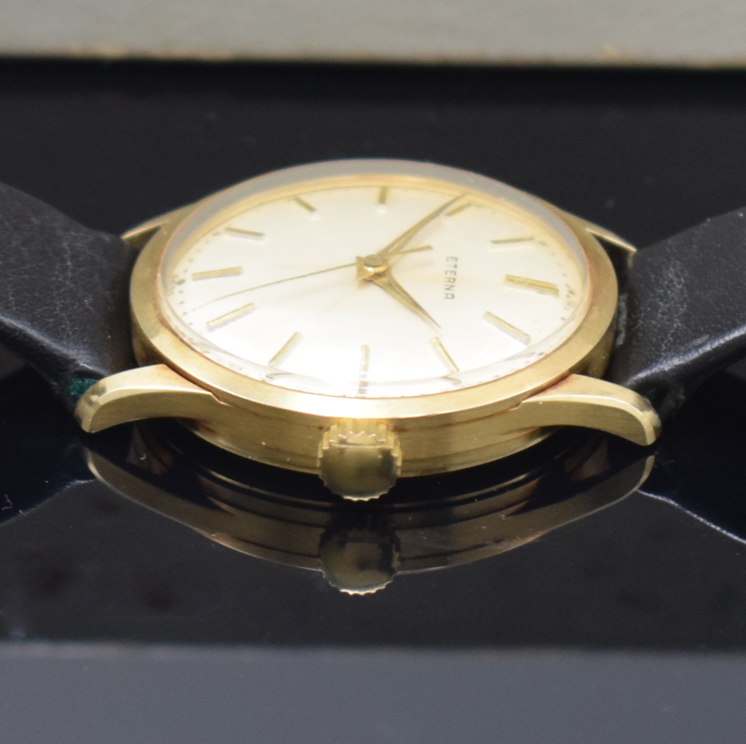 Detail e: ETERNA Herrenarmbanduhr in GG 585/000, Handaufzug, Schweiz um 1960, Boden m. Widmungsgravur verschr., orig. Lederband m. verg. orig. Dornschl., silb. ...