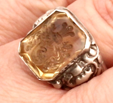 Detail d: Citrin-Siegelring, Silber gepr., facett. Citrin mit Intaglio, Darstellung eines Familienwappens, Ringschultern floral, RW 61, Siegelabdruck anbei