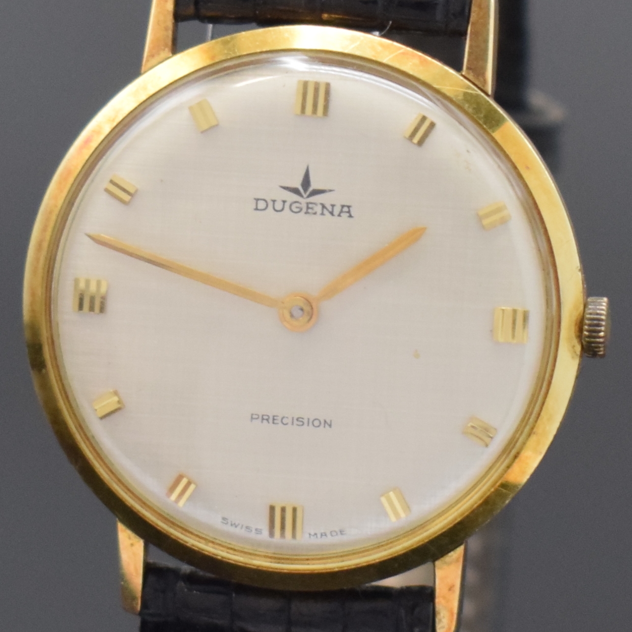 Detail a: DUGENA Precision Armbanduhr in GG 585/000, Schweiz um 1970, Handaufzug, Glasrand aufgedr., silb. Zifferbl. m. gold. Std.-Ind., gold. Zeiger, sign ...